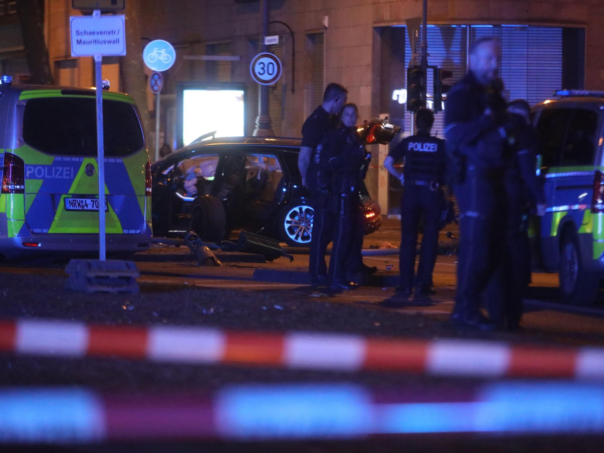Die Polizei ist mit Kräften und Fahrzeugen auf einer Straße im Einsatz. Der Bereich ist mit Flatterband abgesperrt.