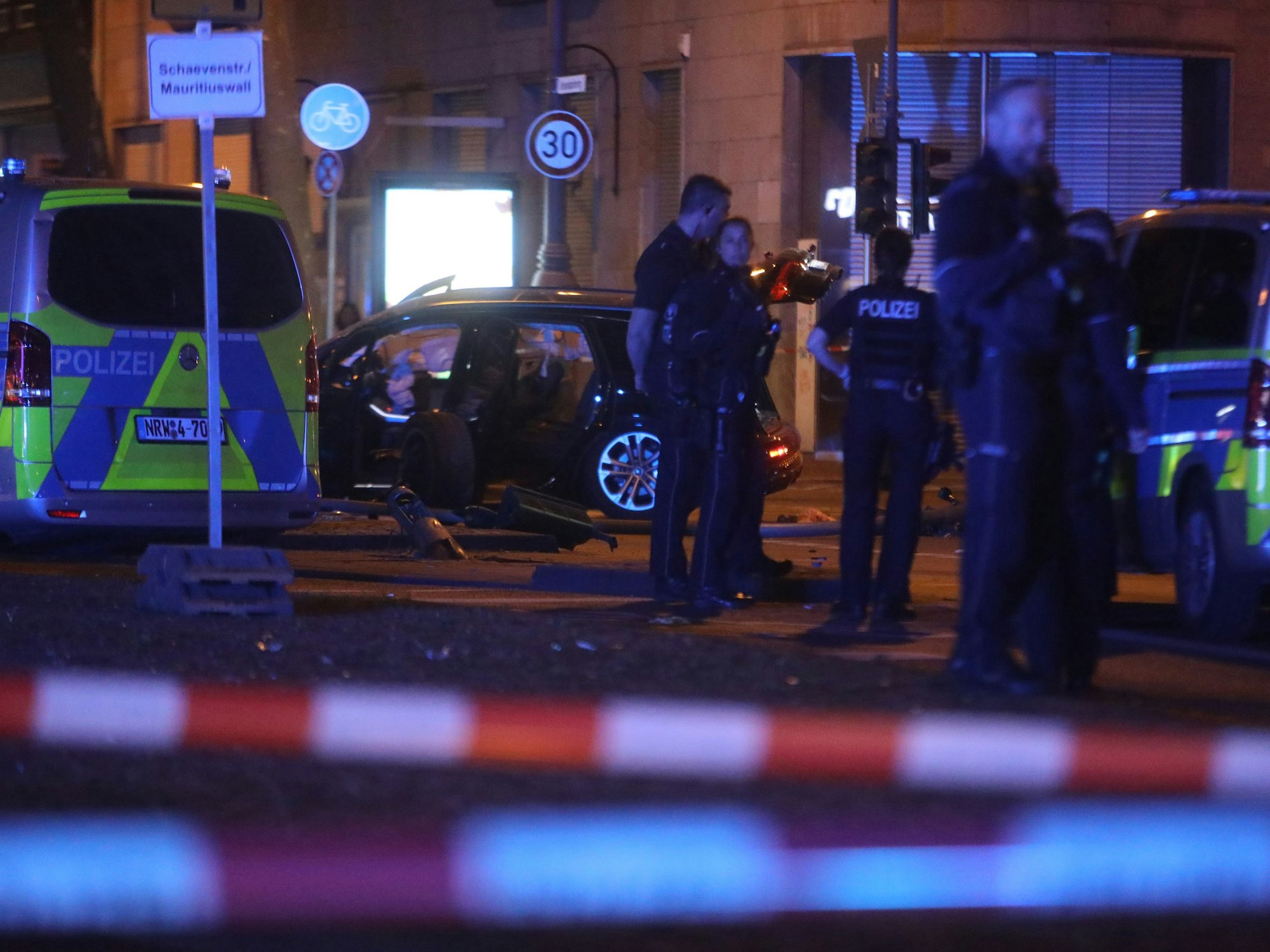 Die Polizei ist mit Kräften und Fahrzeugen auf einer Straße im Einsatz. Der Bereich ist mit Flatterband abgesperrt.