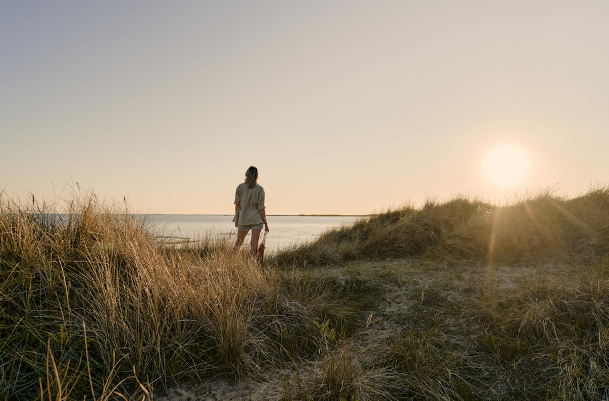Bild vom Küstenort Falkenberg in der Region Halland. Eine Frau blickt aufs Meer.