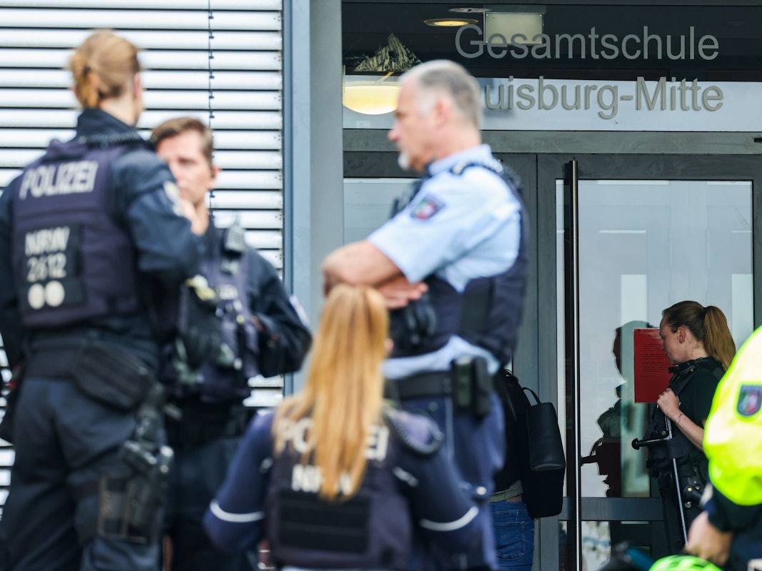 Das Foto zeigt Einsatzkräfte der Polizei vor dem Eingang der Gesamtschule Duisburg-Mitte.