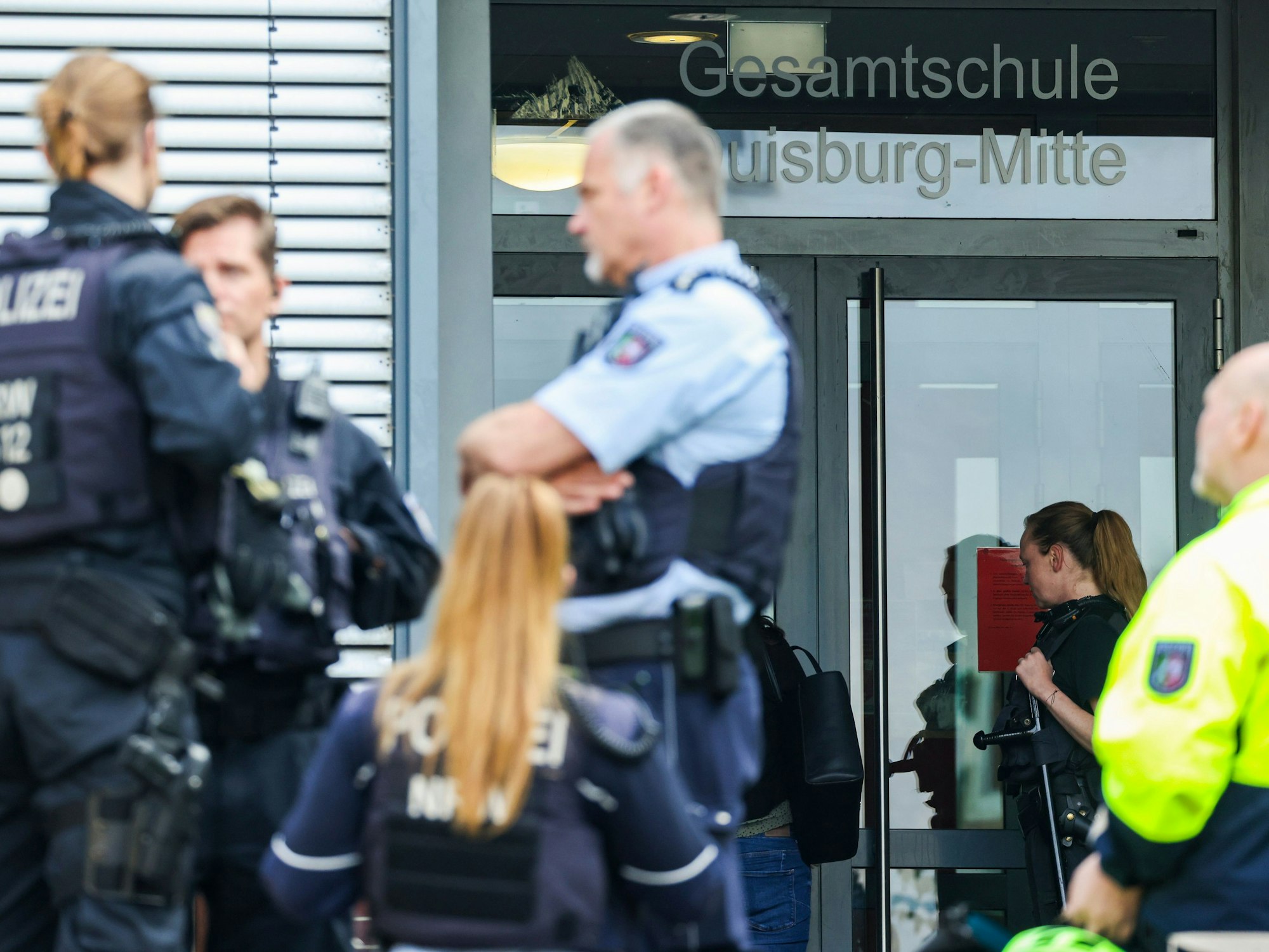 Das Foto zeigt Einsatzkräfte der Polizei vor dem Eingang der Gesamtschule Duisburg-Mitte.
