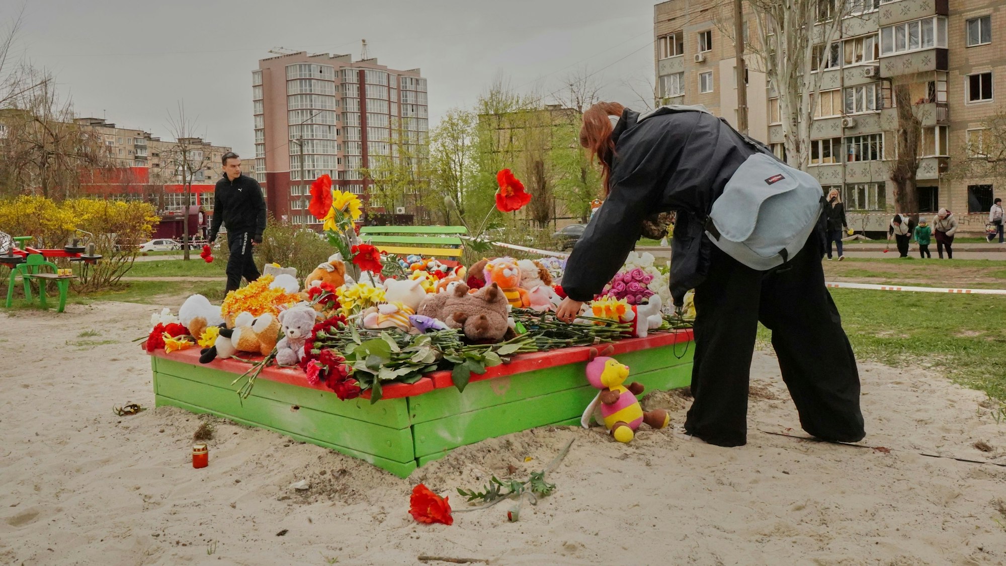 Menschen legen Blumen und Stofftiere nieder. Neun Kinder starben am Freitag (4. April 2025) bei einem russischen Raketenangriff auf einen Kinderspielplatz in Krywyj Rih.