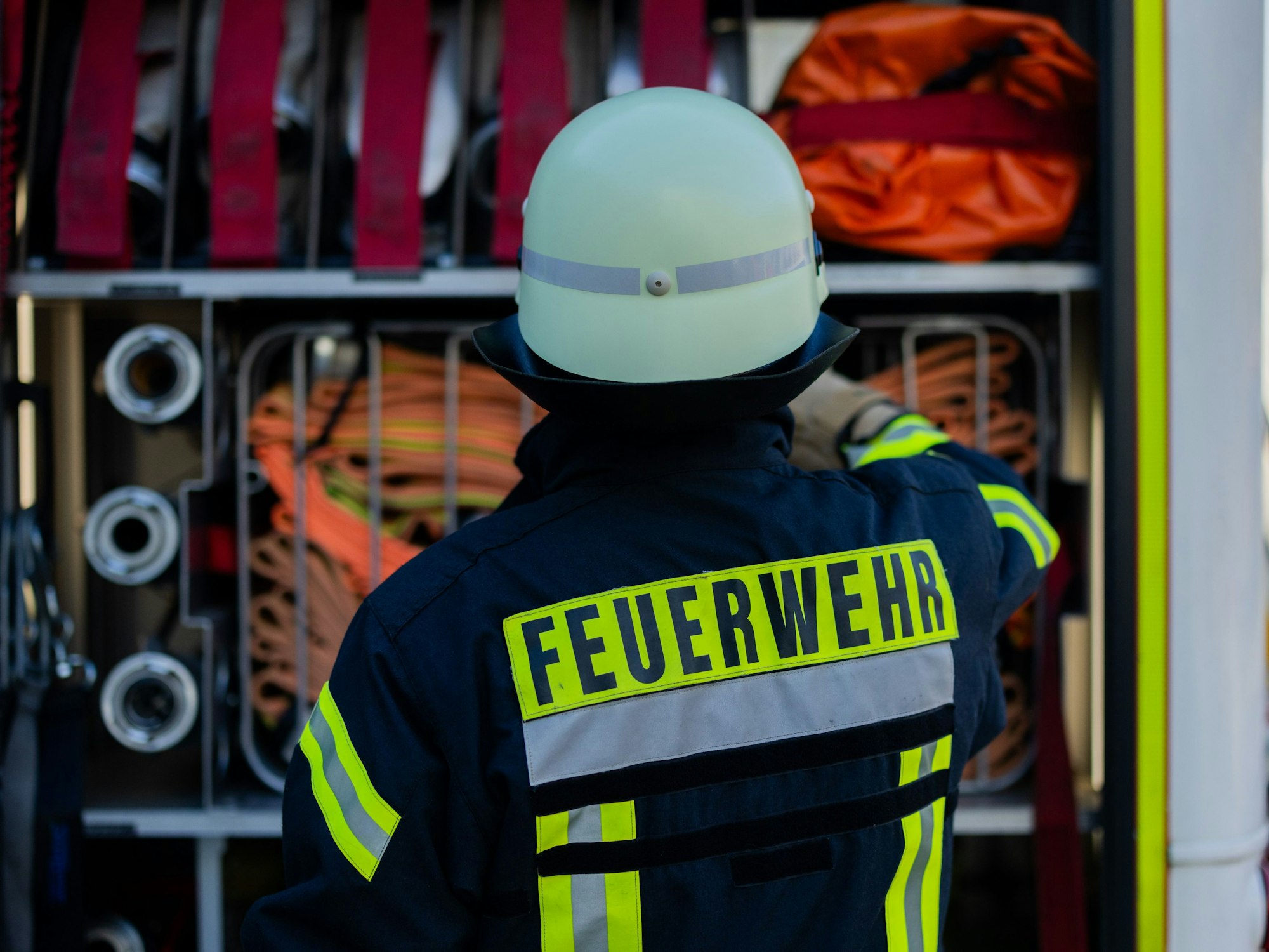 Ein Feuerwehrmann holt Equipment aus einem Einsatzfahrzeug an der Feuerwache der Feuerwehr (Symbolfoto)