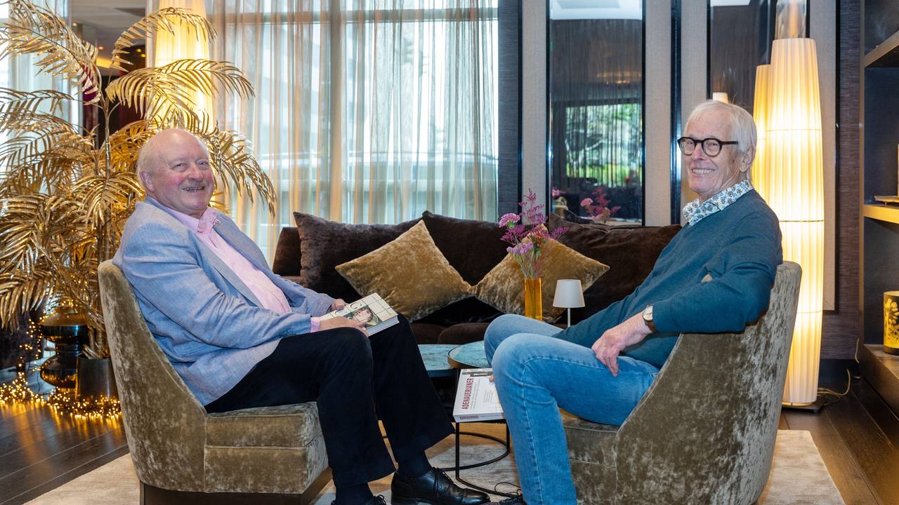 Zwei Männer sitzen an einem Tisch in einer Hotellobby.