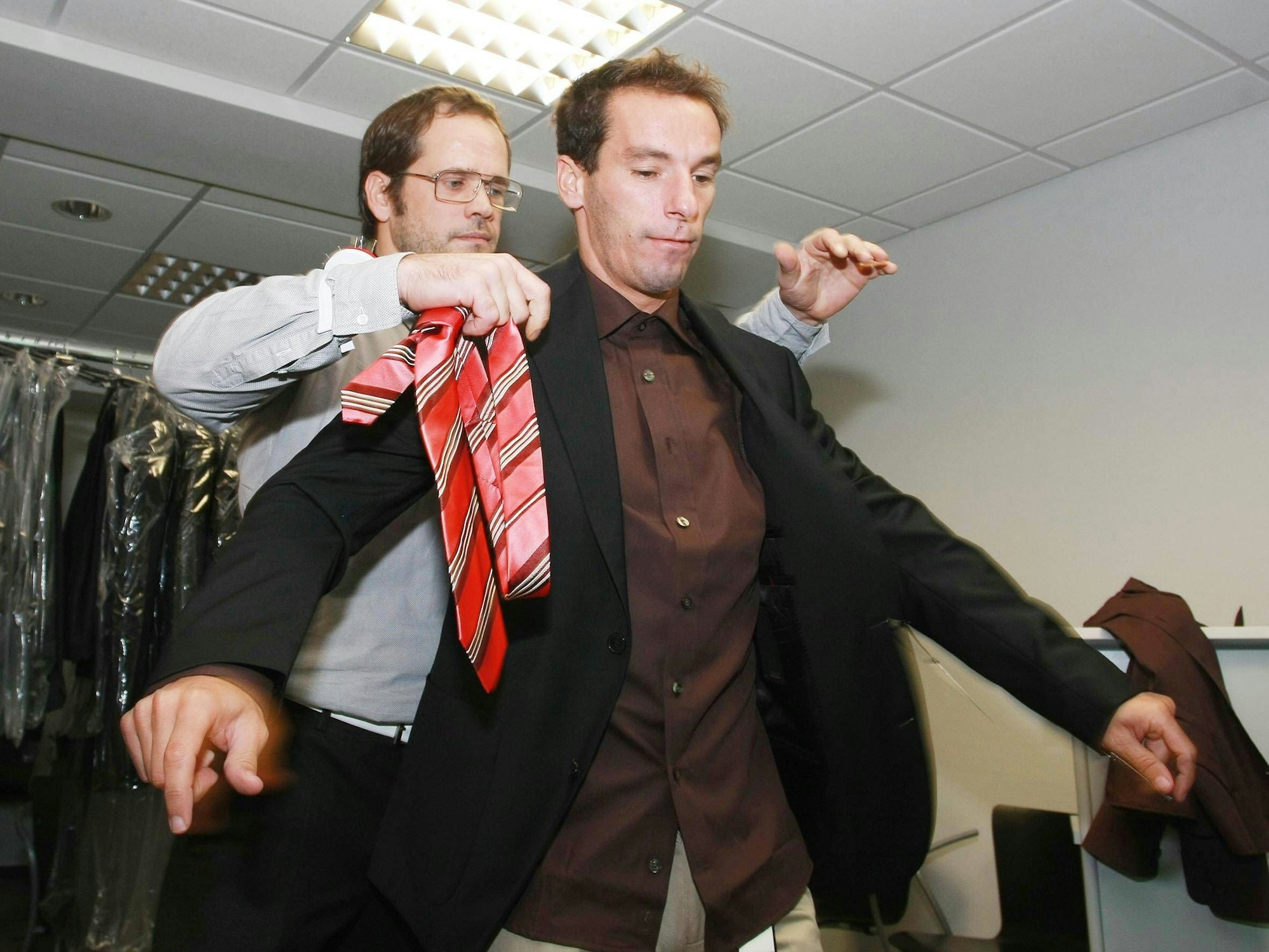 Detlev Bernert kleidet FC-Spieler Petit ein.