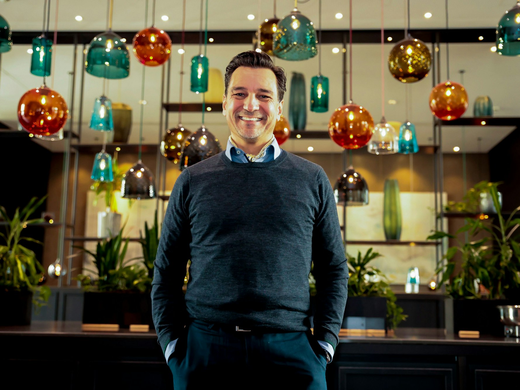 Thorsten Havener steht in einem Raum mit vielen Lampen.