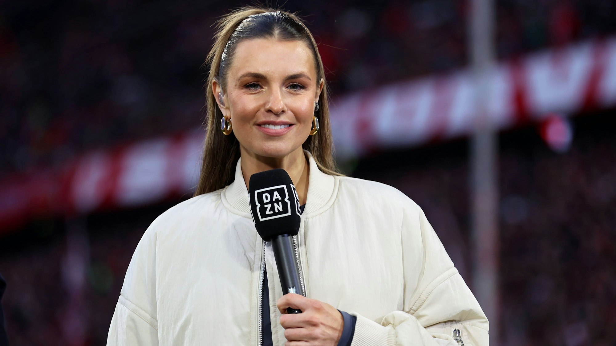 Moderatorin Laura Wontorra hält ein Mikrofon in der Hand.