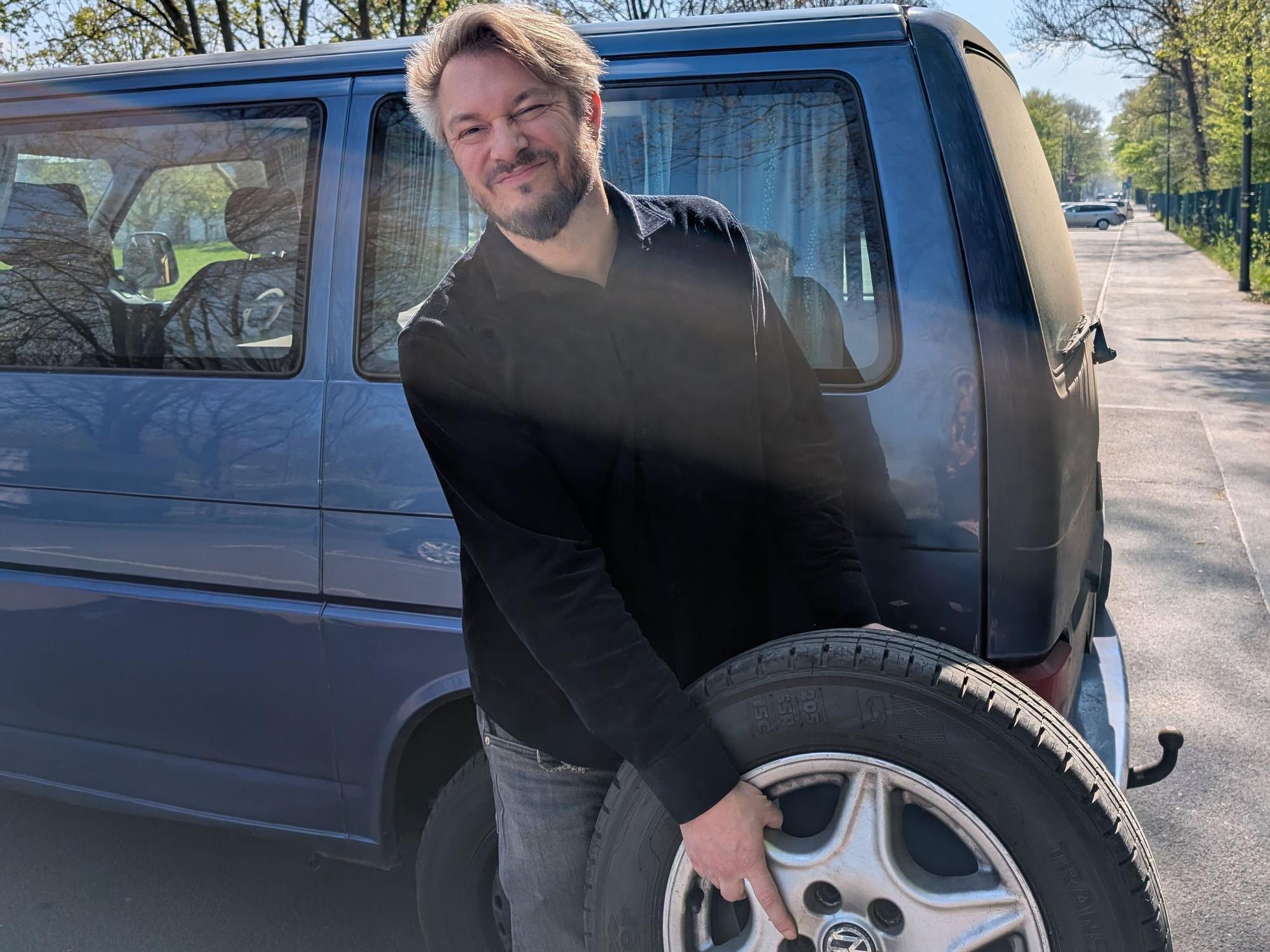 Felix Michel (47) beim Reifenwechseln – schon viermal wurde ein Reifen seines VW-Transporters zerstochen.