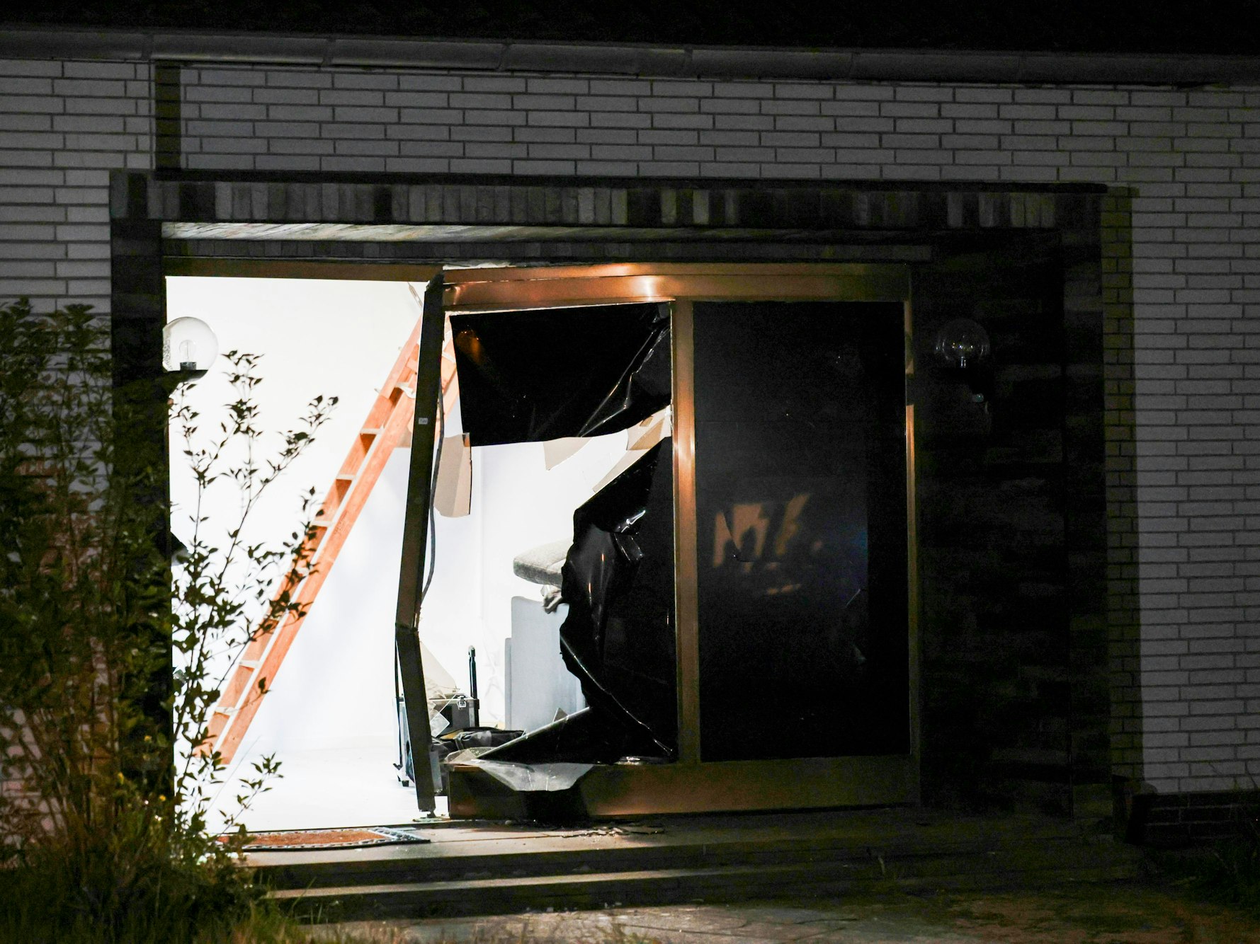 Blick auf den beschädigten Eingang eines Hauses nach einer Durchsuchung durch die Polizei.
