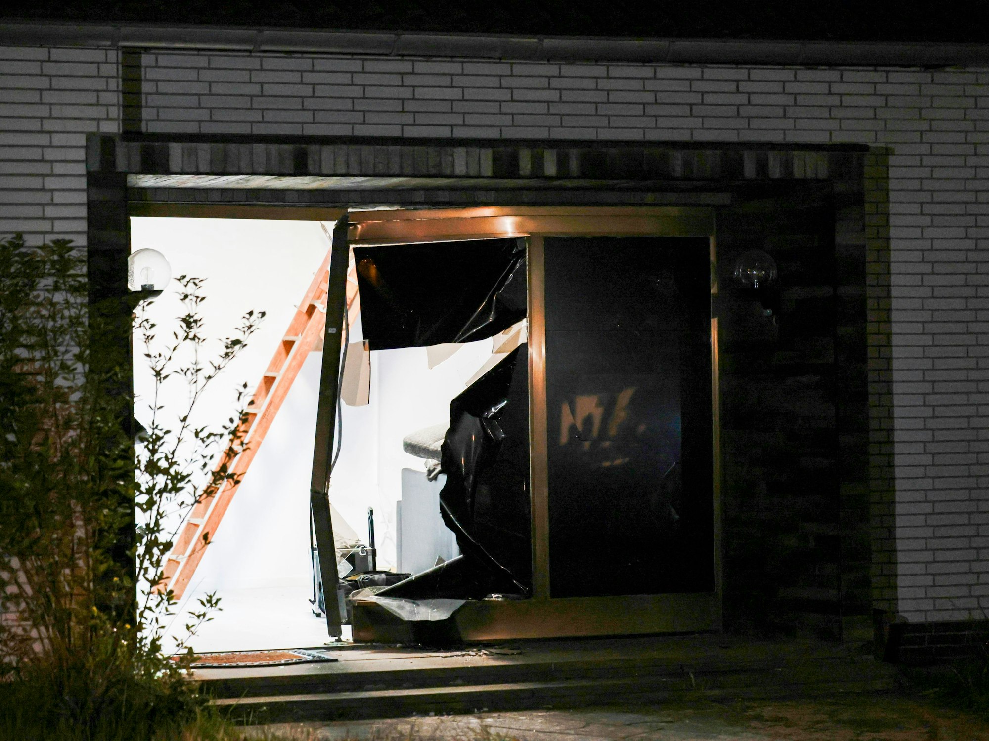 Blick auf den beschädigten Eingang eines Hauses nach einer Durchsuchung durch die Polizei.