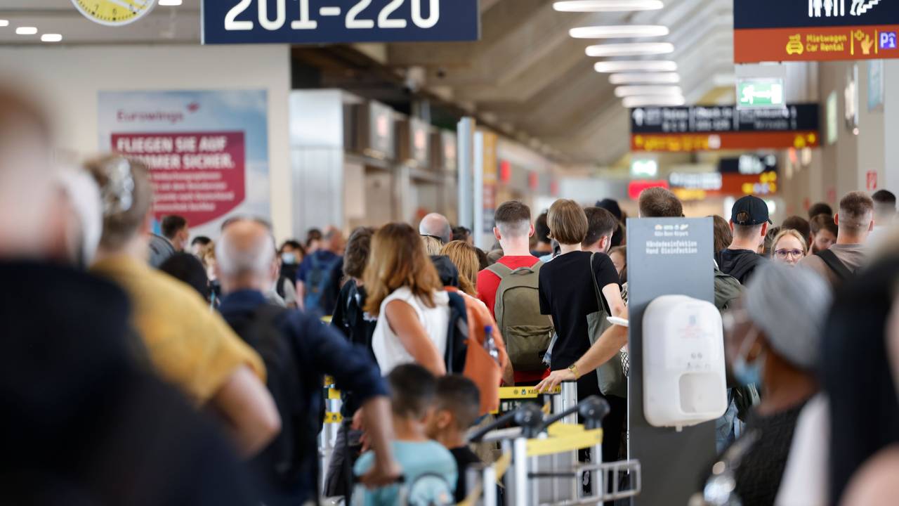 Zahlreiche Passagiere stehen innerhalb und außerhalb der Terminals an, um durch die Sicherheitskontrolle zu gelangen.
