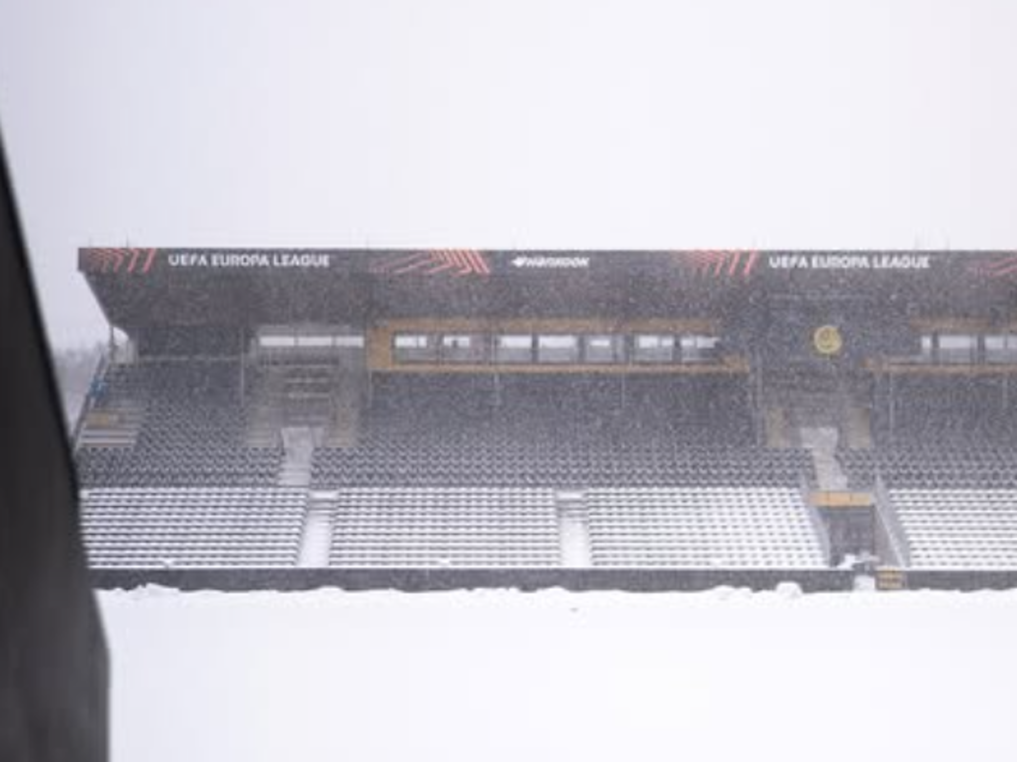 Tribünen und der Rasen sind von Schnee bedeckt.