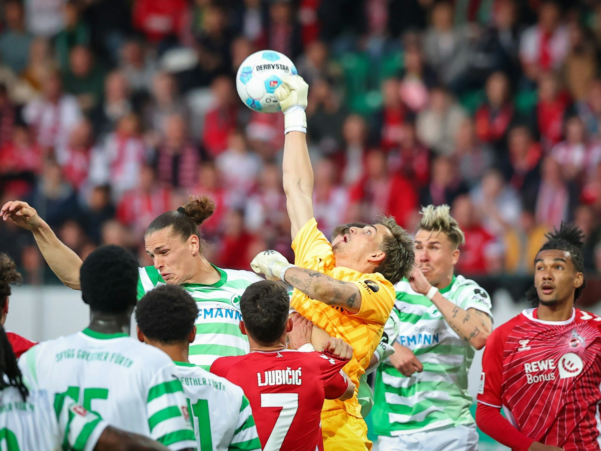 Der Fürther Torwart Nahuel Noll (M) boxt gegen den 1. FC Köln den Ball aus der Menge.
