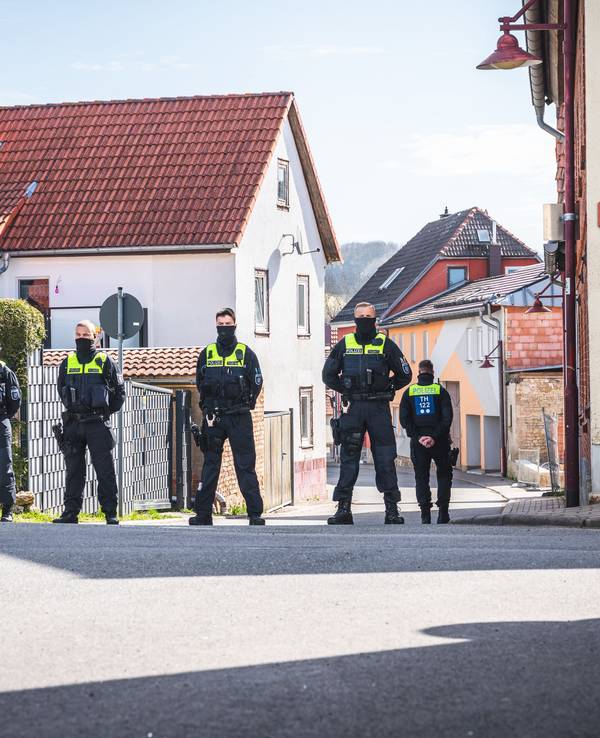 Polizeibeamte sichern die Umgebung um einen Tatort in Klettbach. Vier Menschen sind im thüringischen Klettbach im Weimarer Land tot aufgefunden worden.