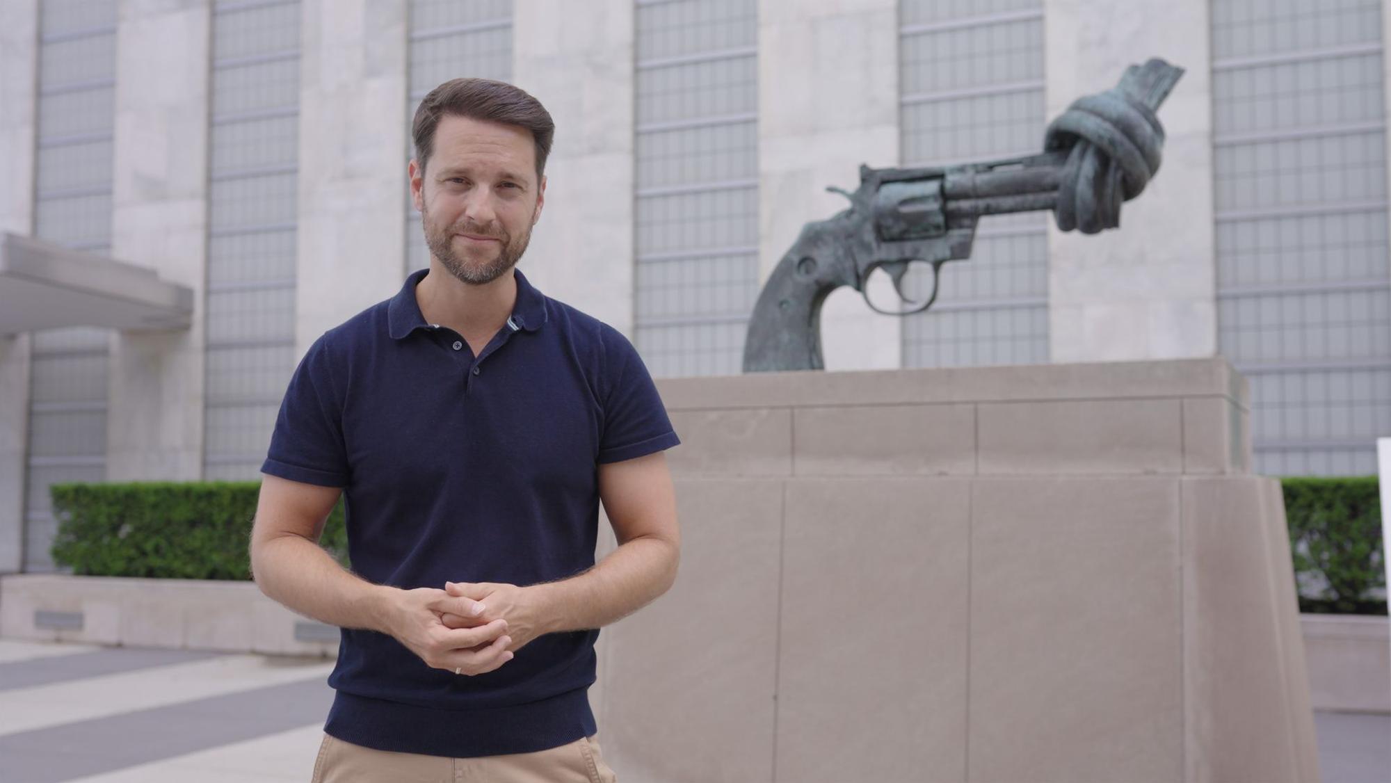 Mirko Drotschmann vor dem Friedenssymbol "Non Violence" von Carl Fredrik Reuterswärd auf dem UN-Gelände in New York.
