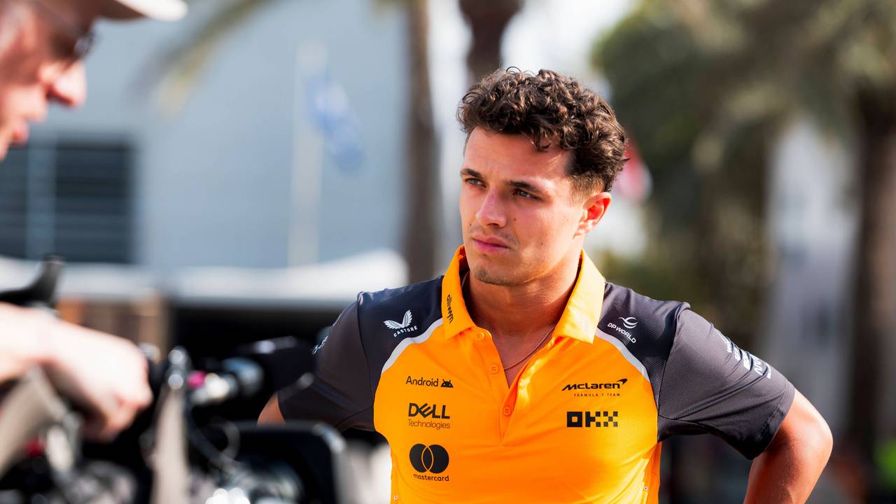 Lando Norris hat die Hände in der Hüfte und schaut grimmig.