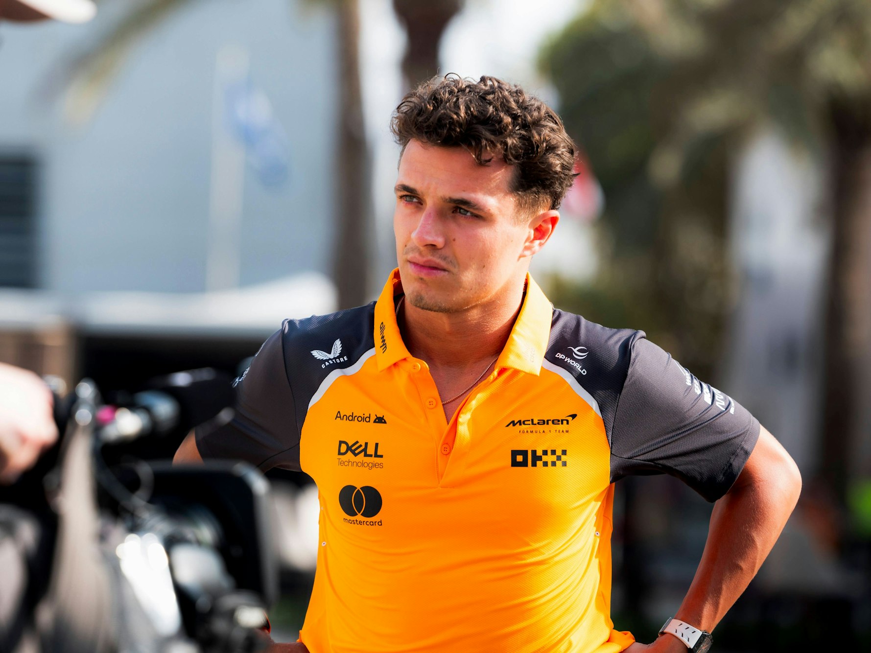 Lando Norris hat die Hände in der Hüfte und schaut grimmig.