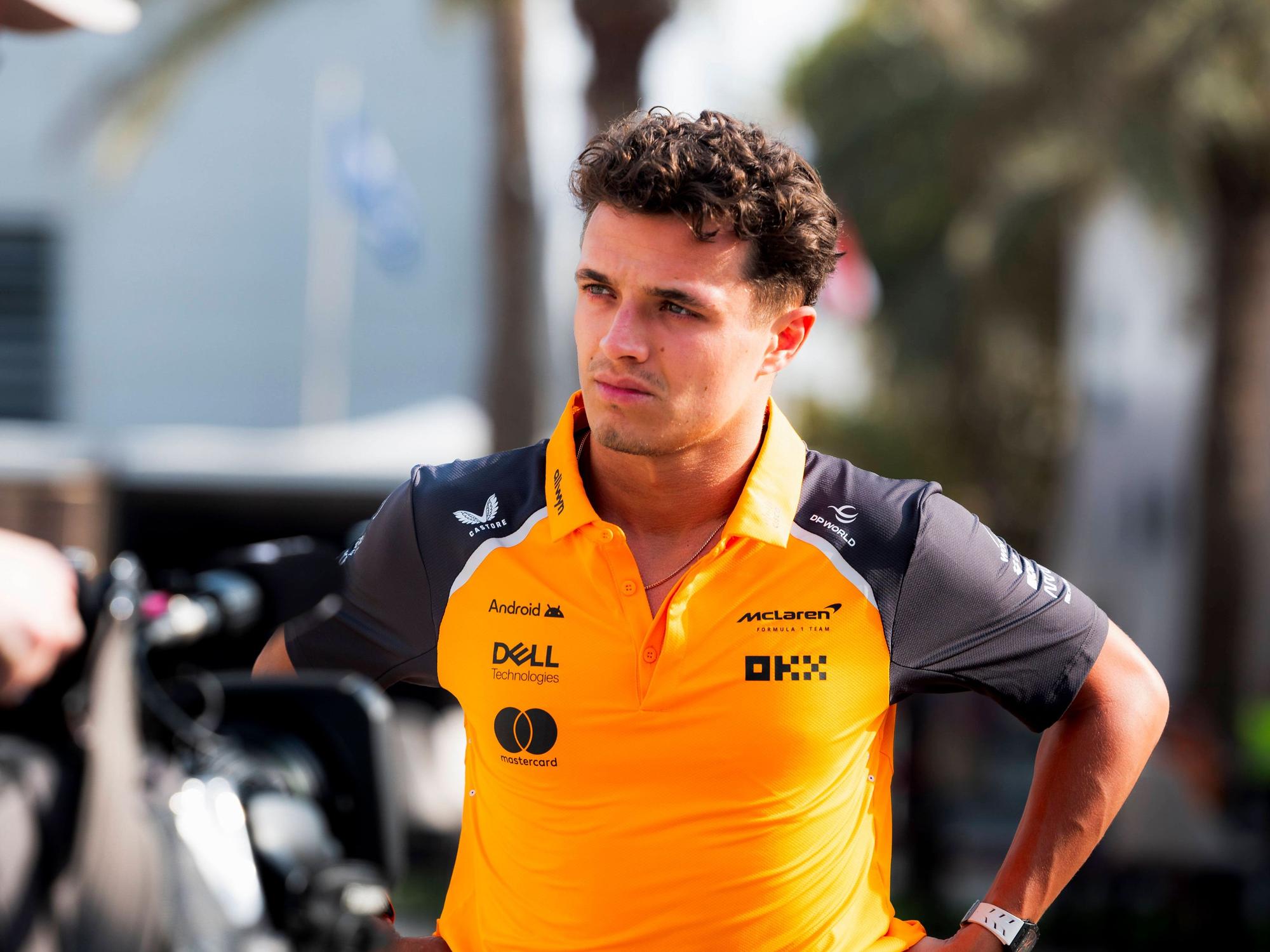 Lando Norris hat die Hände in der Hüfte und schaut grimmig.