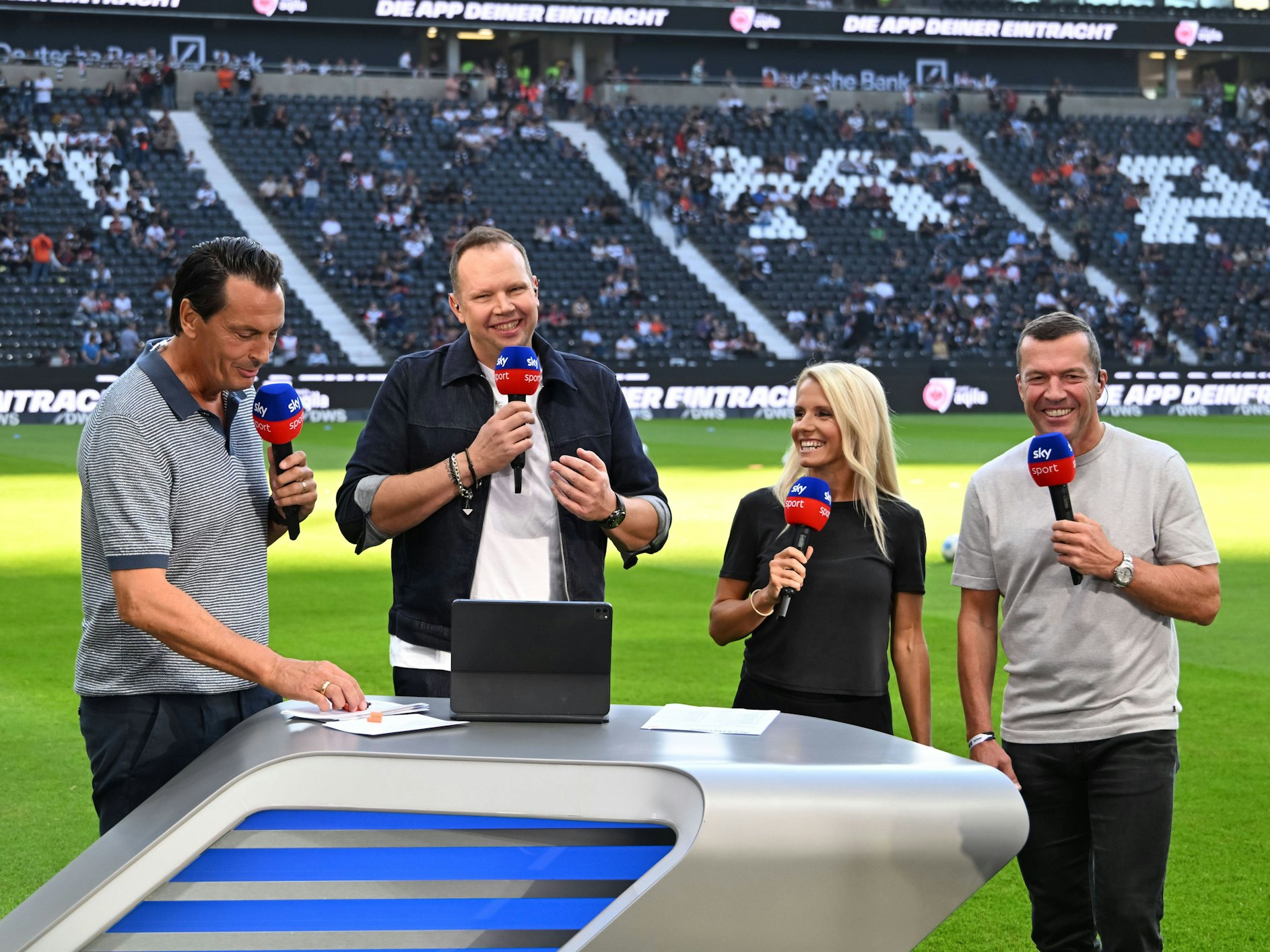 Sebastian Hellmann, Wolff Fuss, Julia Simic und Lothar Matthäus lachen am Presenter-Pult.