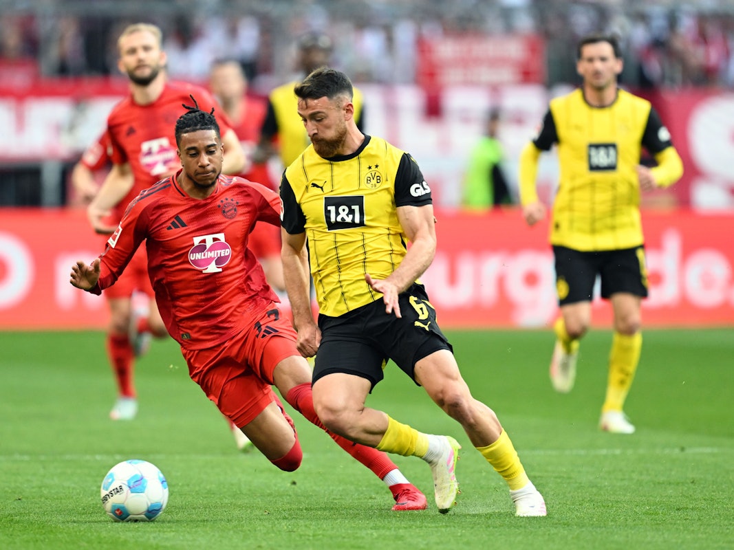Münchens Michael Olise (l.) und Dortmunds Salih Özcan kämpfen um den Ball.
