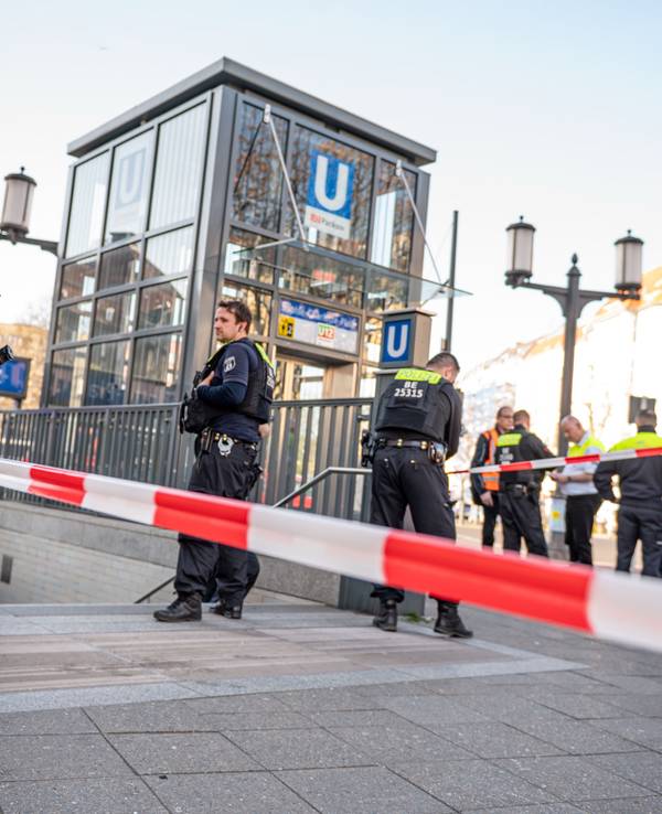 Berliner Polizisten stehen am 12. April 2025 nach einer Gewalttat vor dem U-Bahn-Eingang Sophie-Charlotte-Platz.