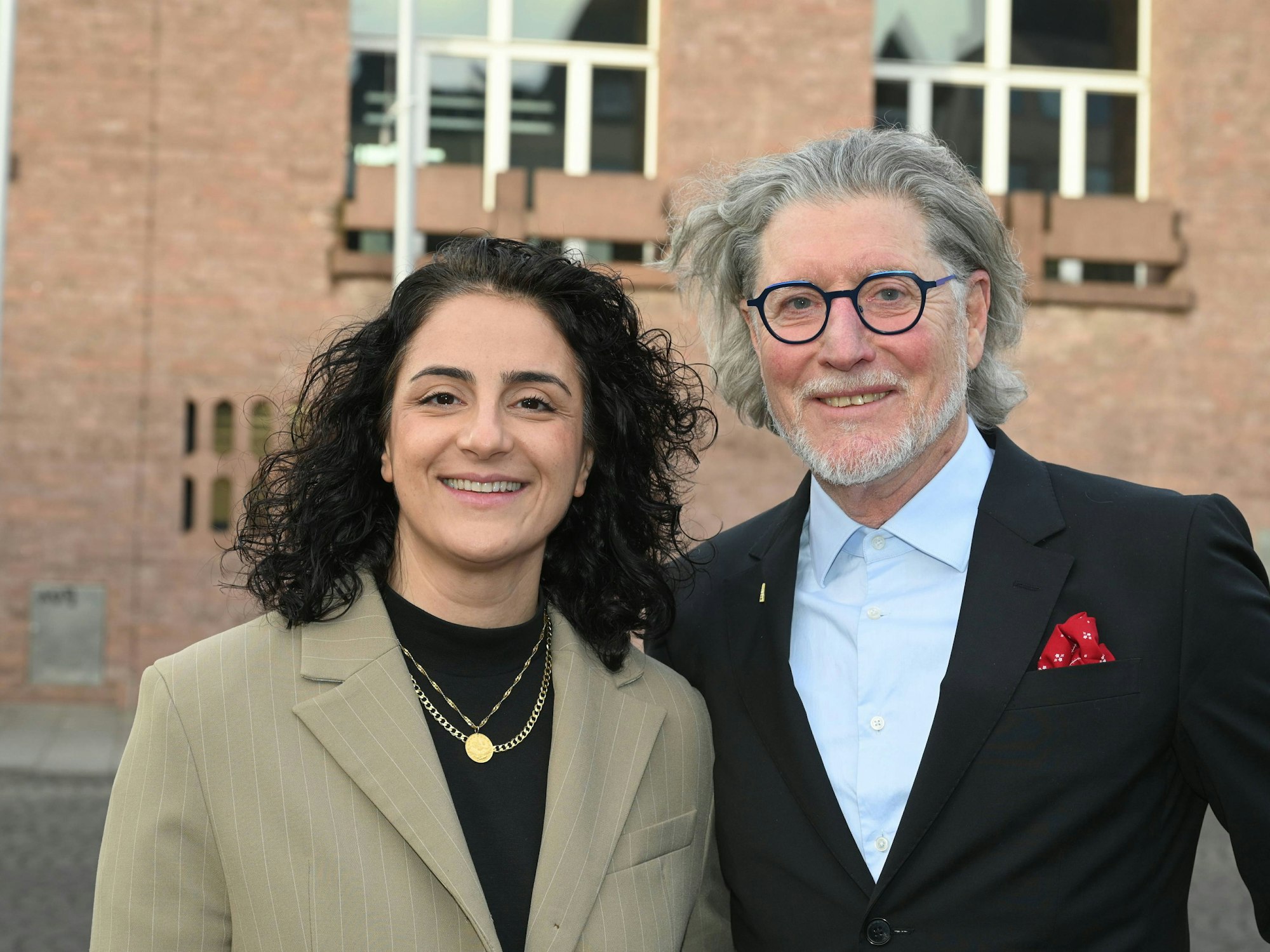 Tugba Tekkal und Toni Schumacher lächeln in die Kamera.