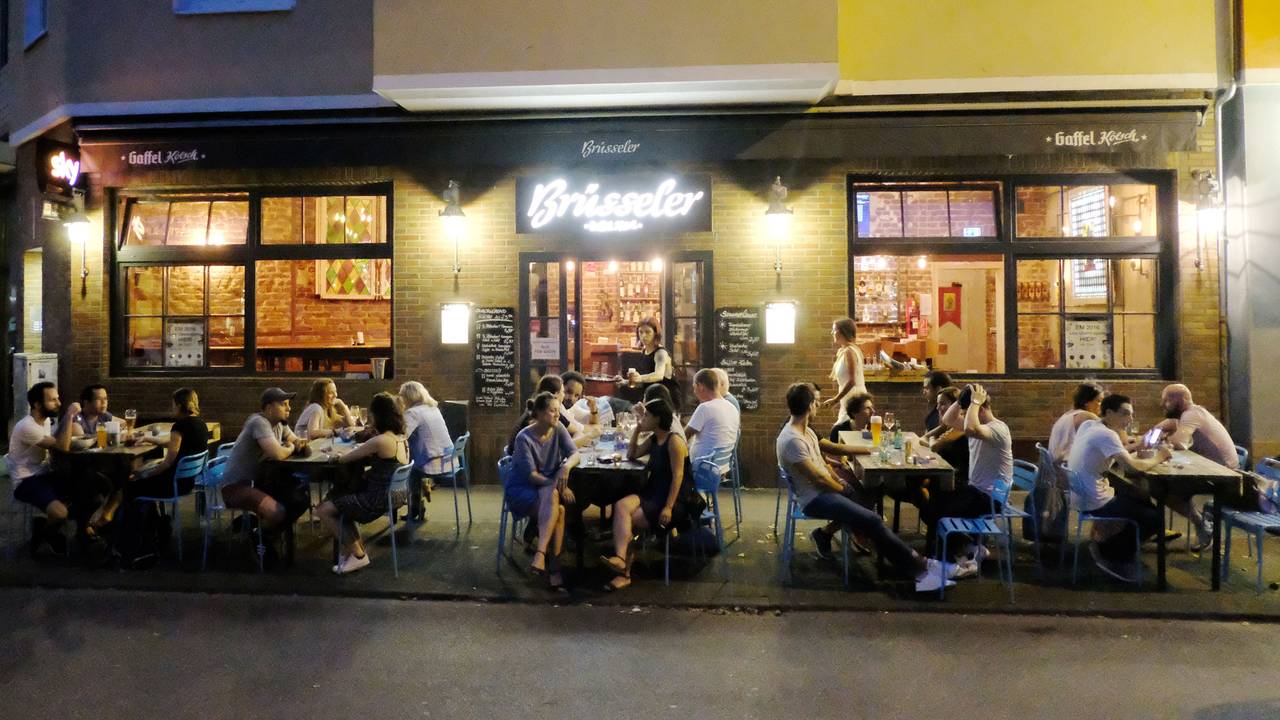Menschen sitzen auf der Terrasse einer Gaststätte.