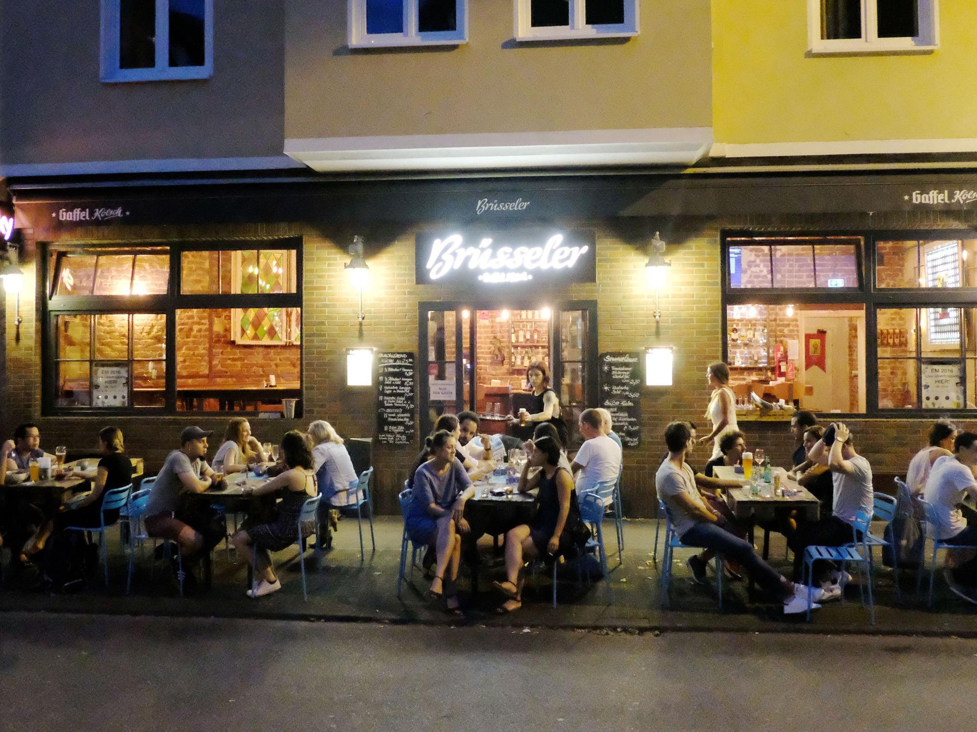 Menschen sitzen auf der Terrasse einer Gaststätte.