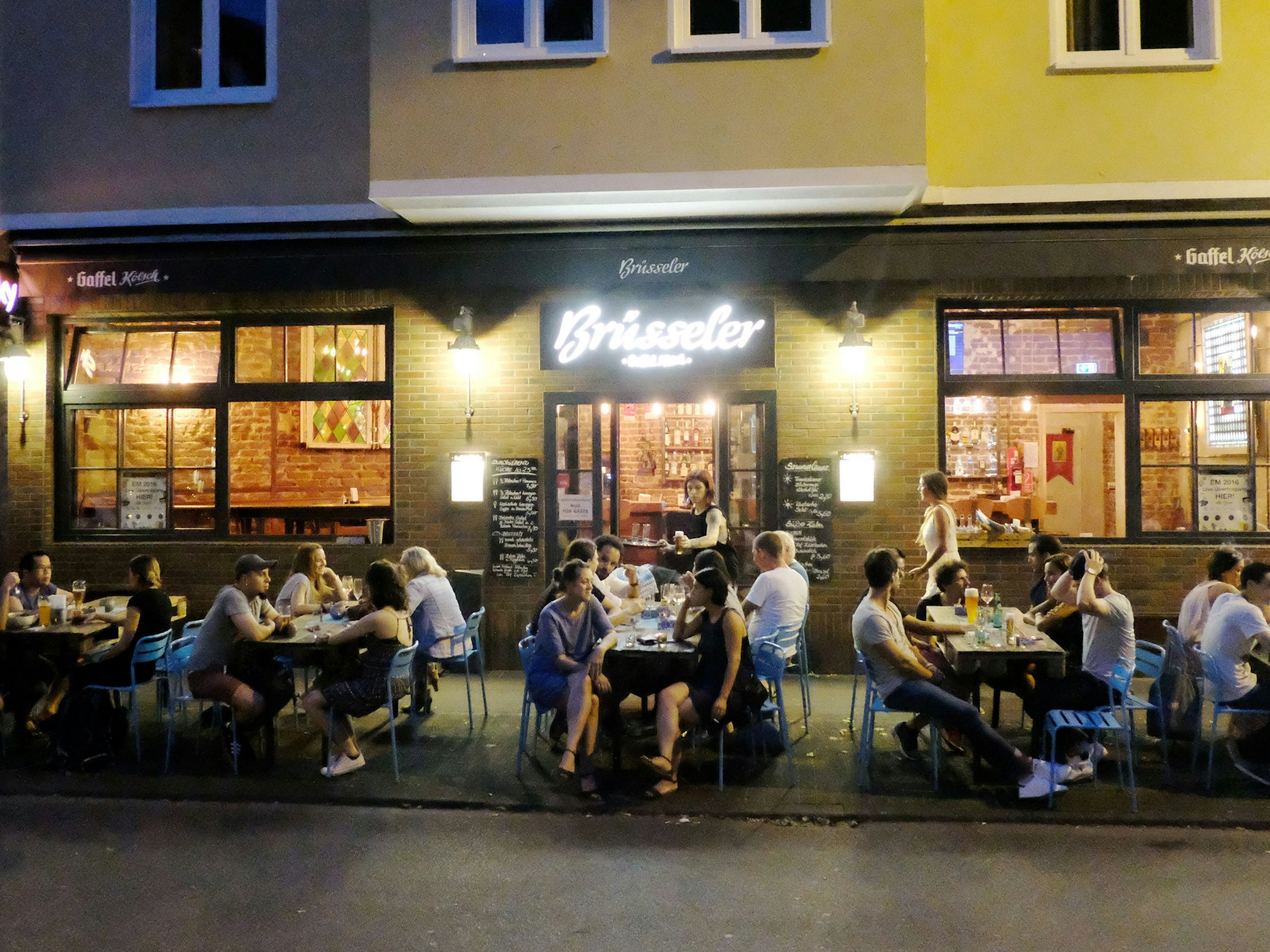 Menschen sitzen auf der Terrasse einer Gaststätte.