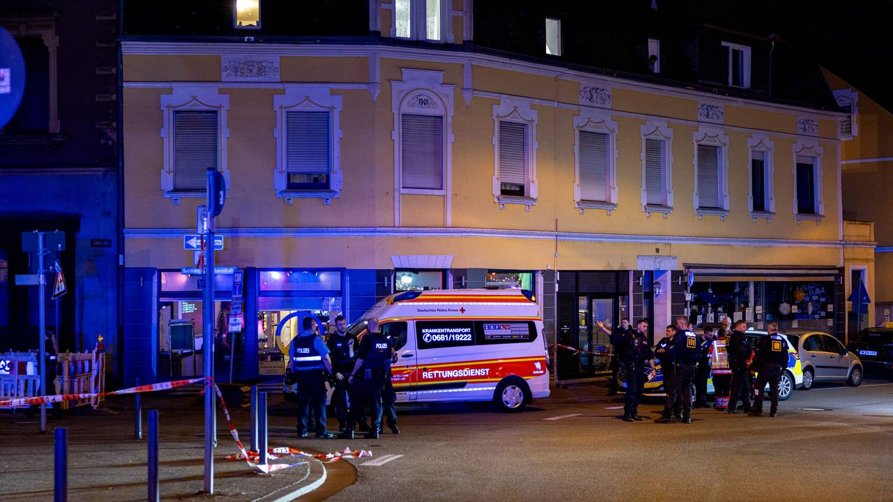 Rettungskräfte und Polizisten stehen am 11. April 2025 auf einer Straße im Saarbrücker Bezirk Dudweiler. Bei einer Auseinandersetzung mit fünf Beteiligten in Saarbrücken sind vier Menschen mit einem Messer verletzt worden.