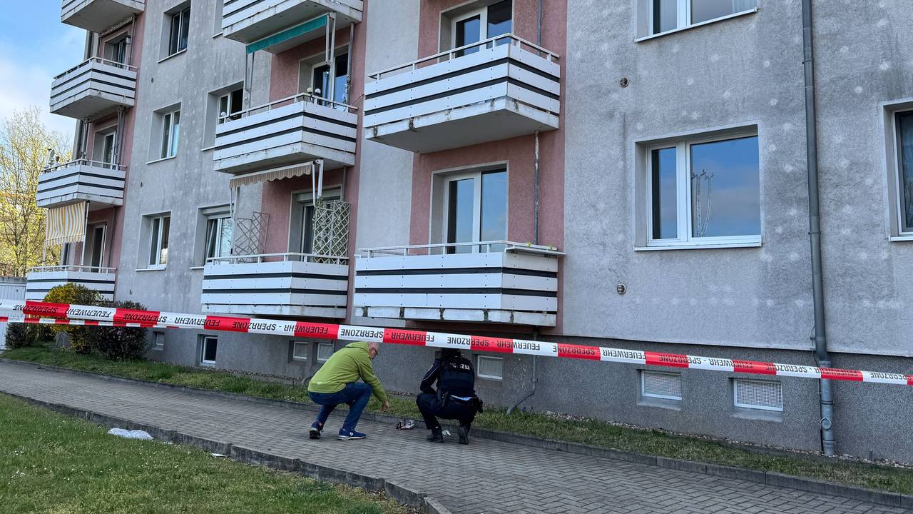 Ermittler der Polizei untersuchen am 12. April 2025 Spuren unter Balkonen an einer Hausfassade. Eine Frau und ein Kind sind beim Sturz von einem Balkon schwer verletzt worden und in ein Krankenhaus gebracht worden.