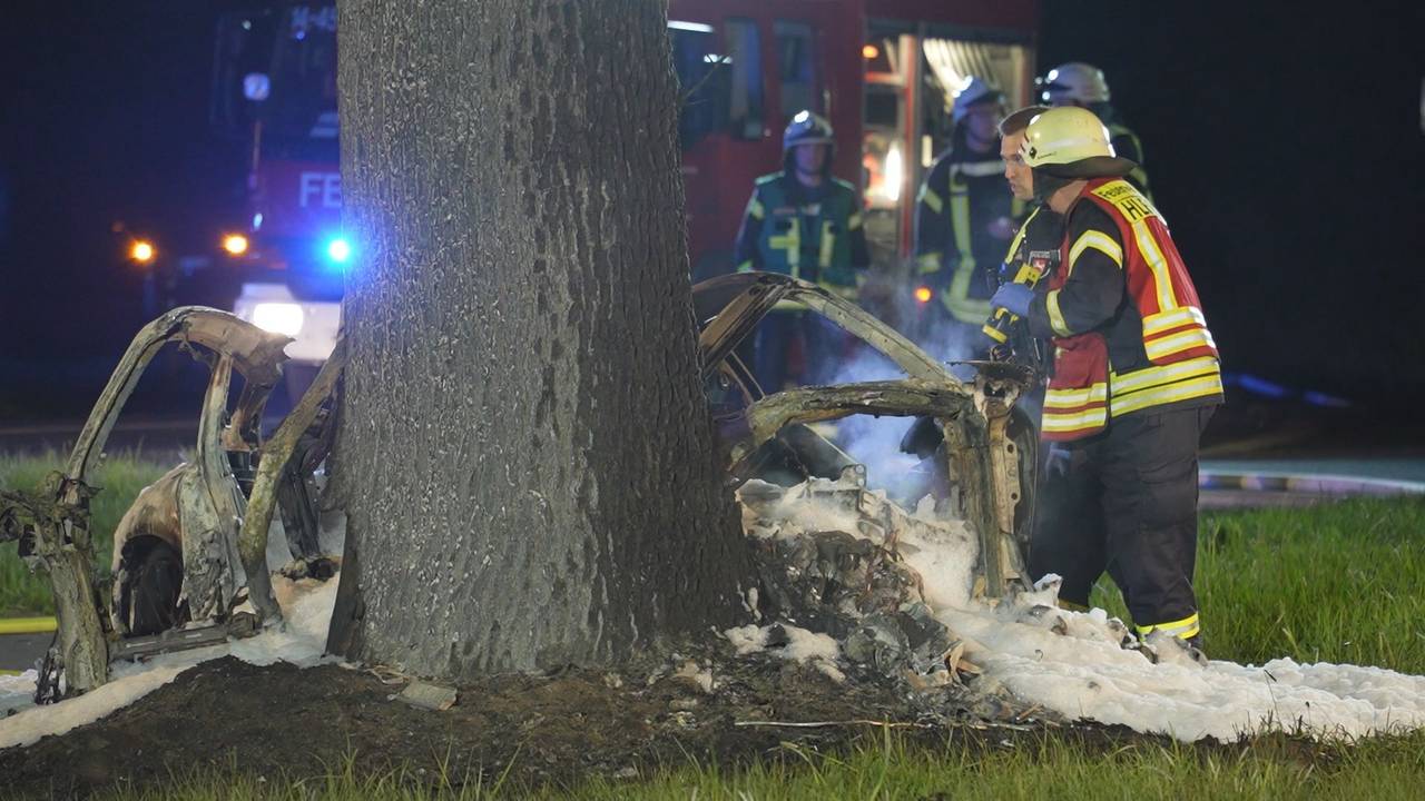 Einsatzkräfte stehen am 13. April 2025 an der Unfallstelle in Syke (Niedersachen). Zwei 17-Jährige sind in der Nacht mit einem Sportwagen gegen einen Baum geprallt und im Wagen verbrannt.