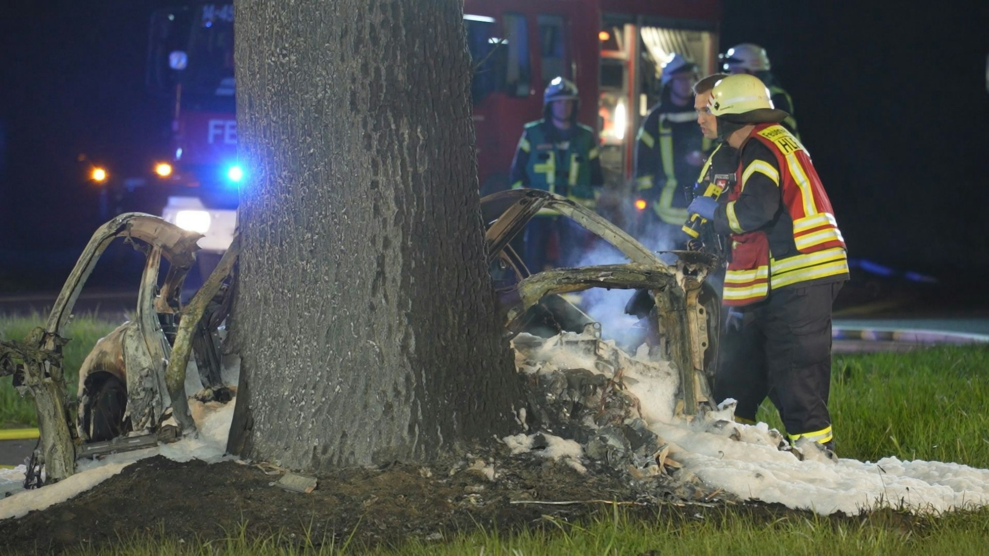 Einsatzkräfte stehen am 13. April 2025 an der Unfallstelle in Syke (Niedersachen). Zwei 17-Jährige sind in der Nacht mit einem Sportwagen gegen einen Baum geprallt und im Wagen verbrannt.