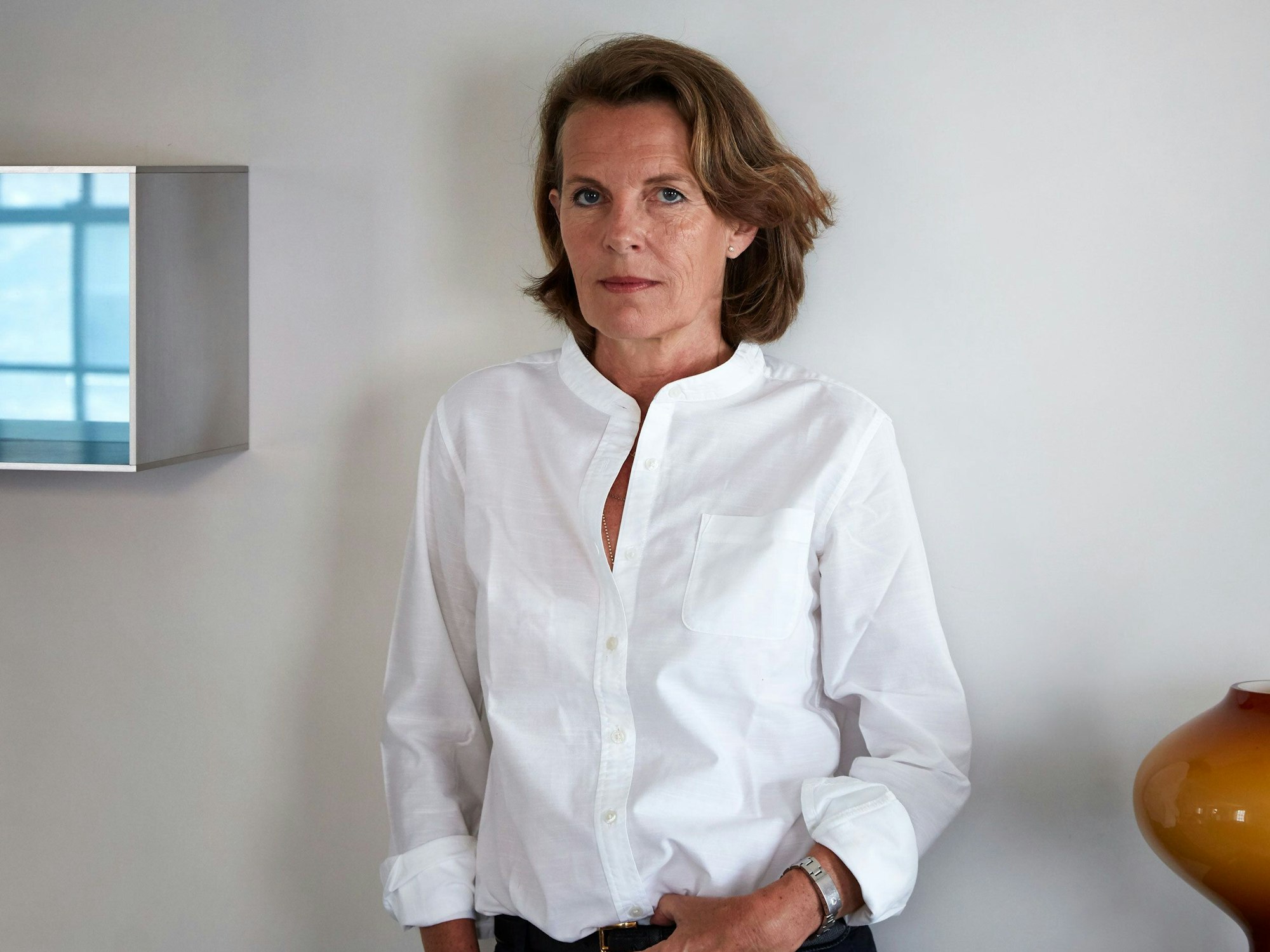 Eine Frau steht vor einer Wand.