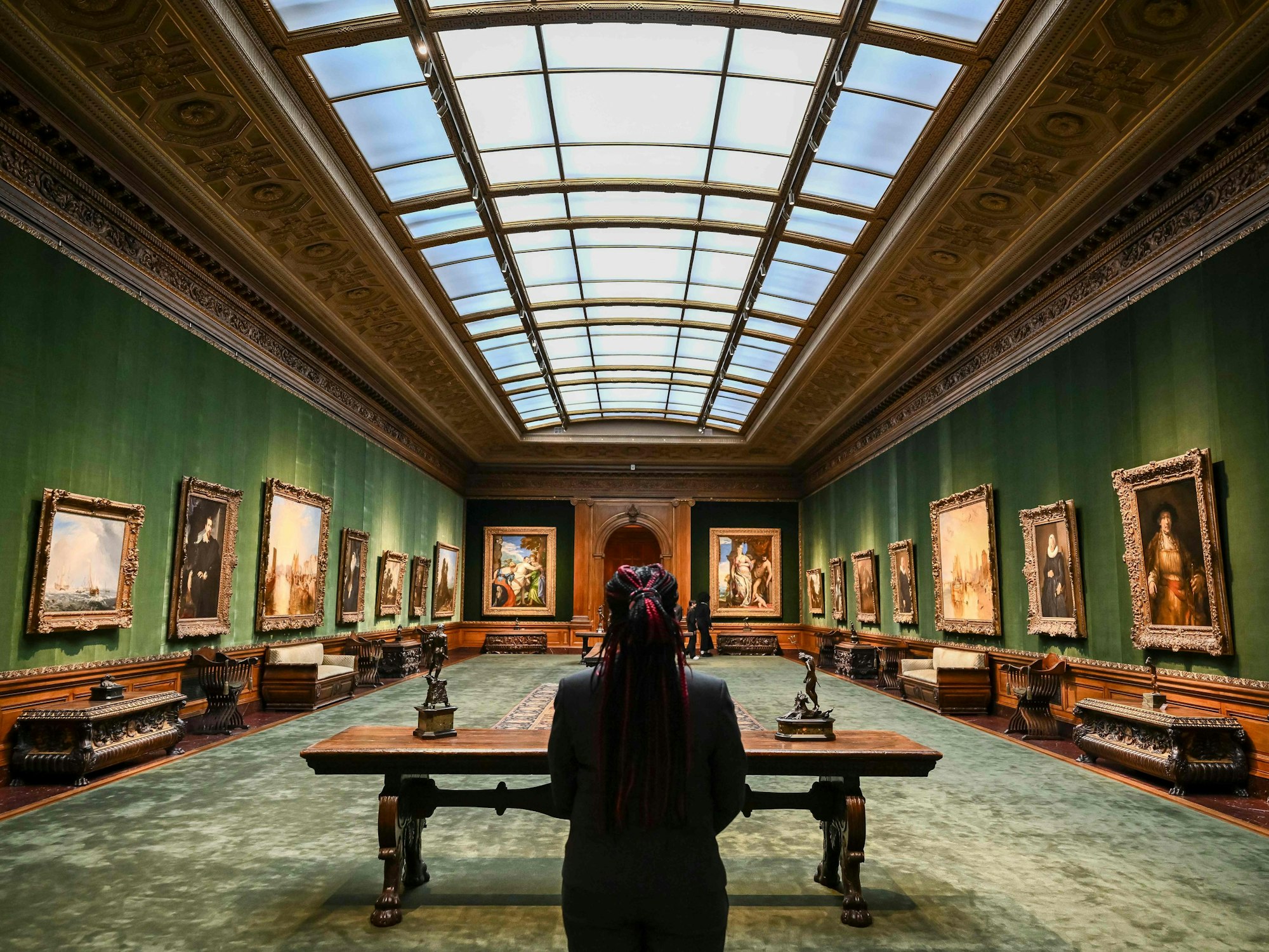 Eine Person sitzt in einem Museum an einem Tisch.