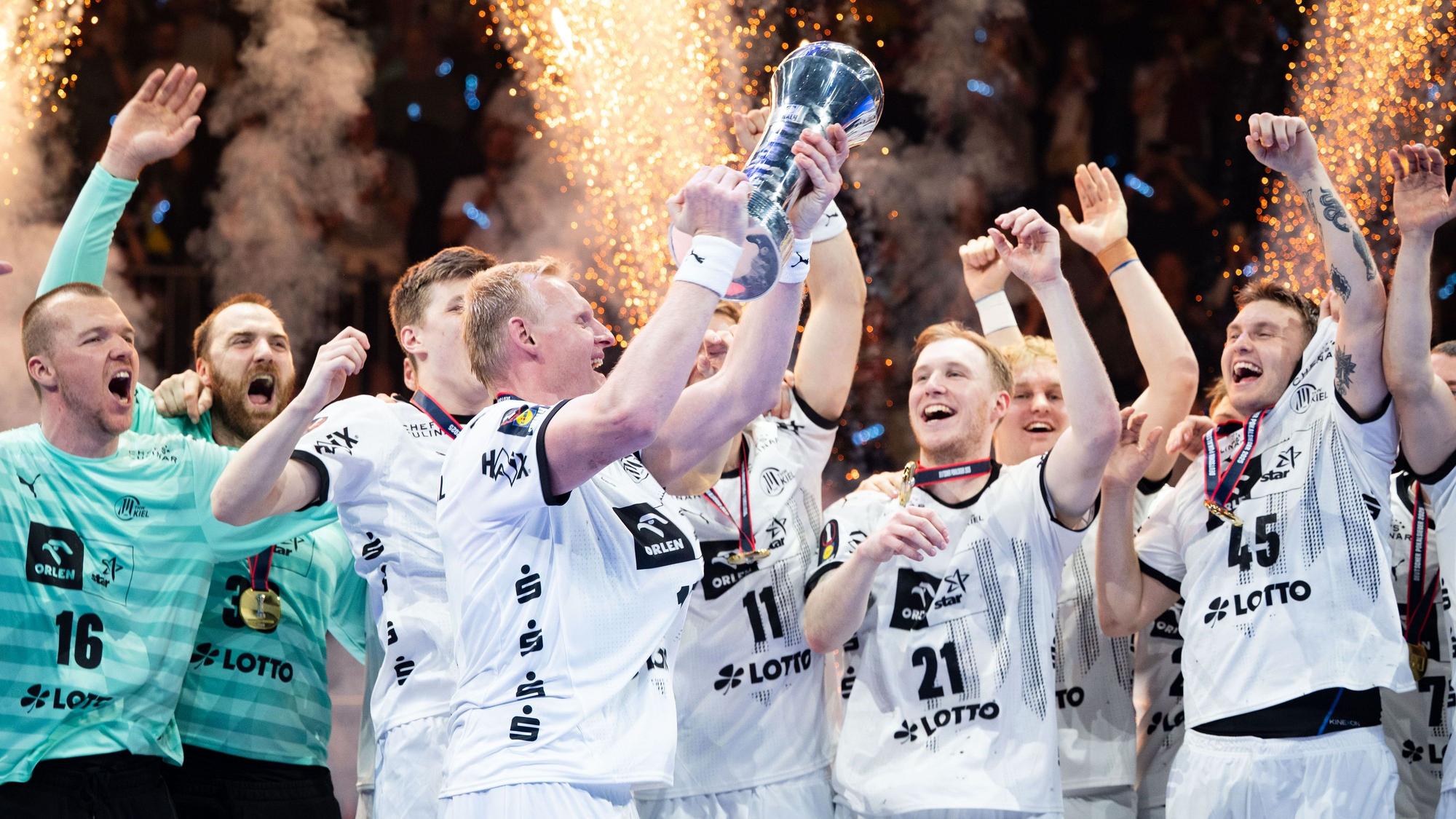 Kiels Patrick Wiencek stemmt nach der Partie den Pokal in die Höhe.