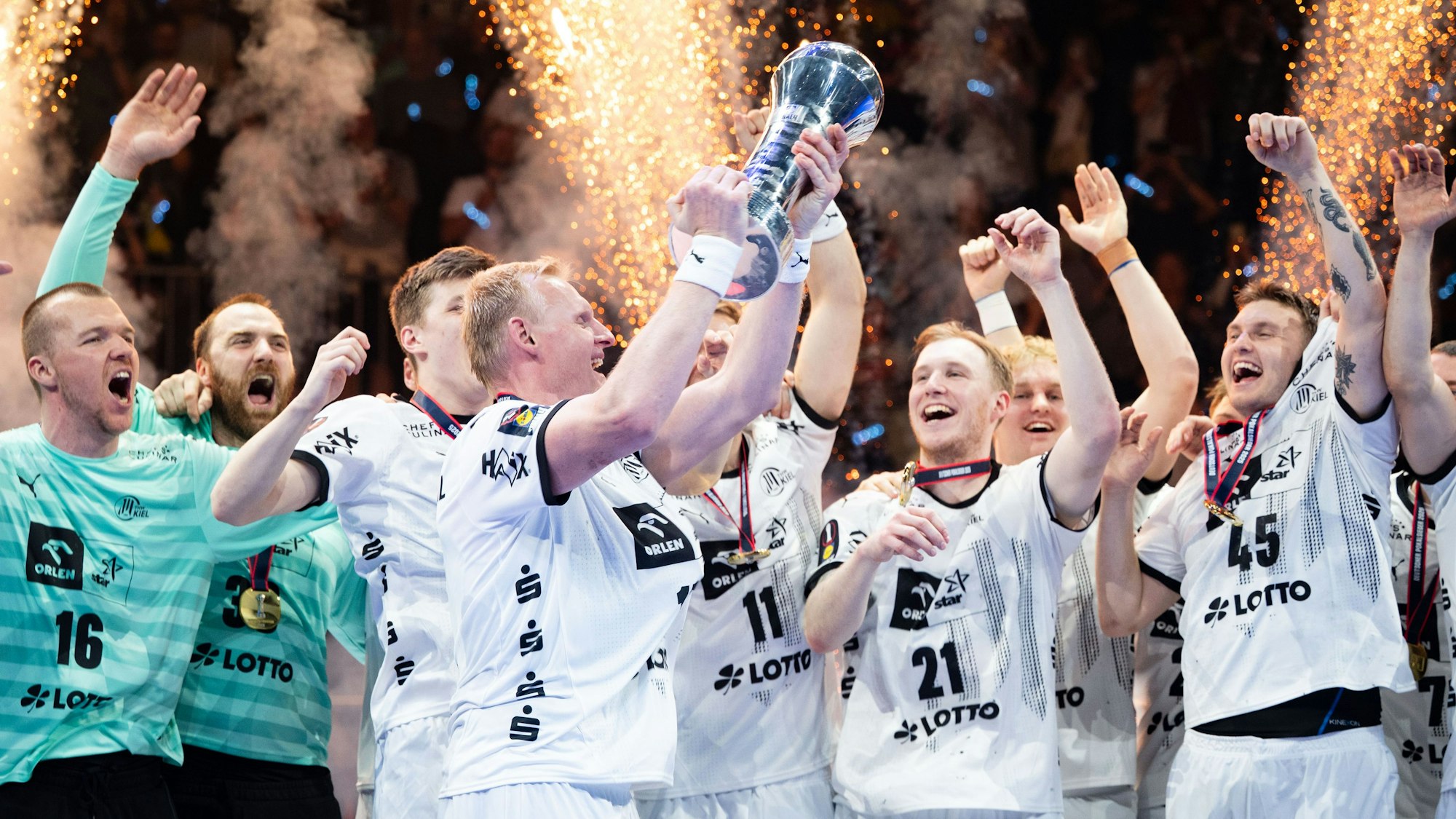 Kiels Patrick Wiencek stemmt nach der Partie den Pokal in die Höhe.