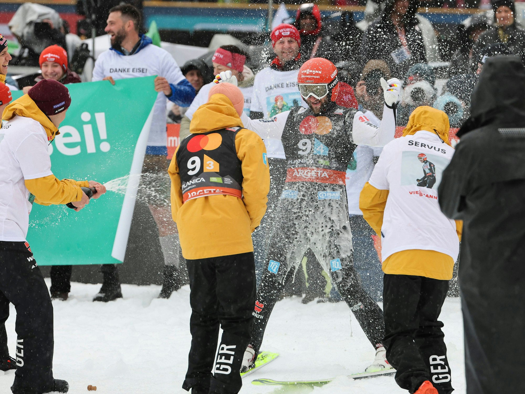 Markus Eisenbichler wird mit Champagner bespritzt.
