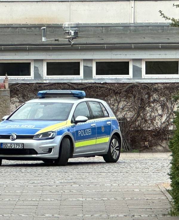 Ein Polizeiauto steht an einer Oberschule.