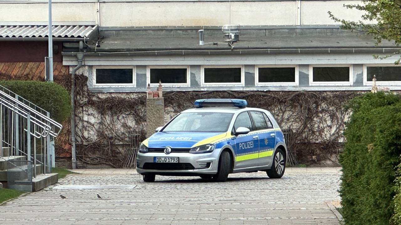 Ein Polizeiauto steht an einer Oberschule.