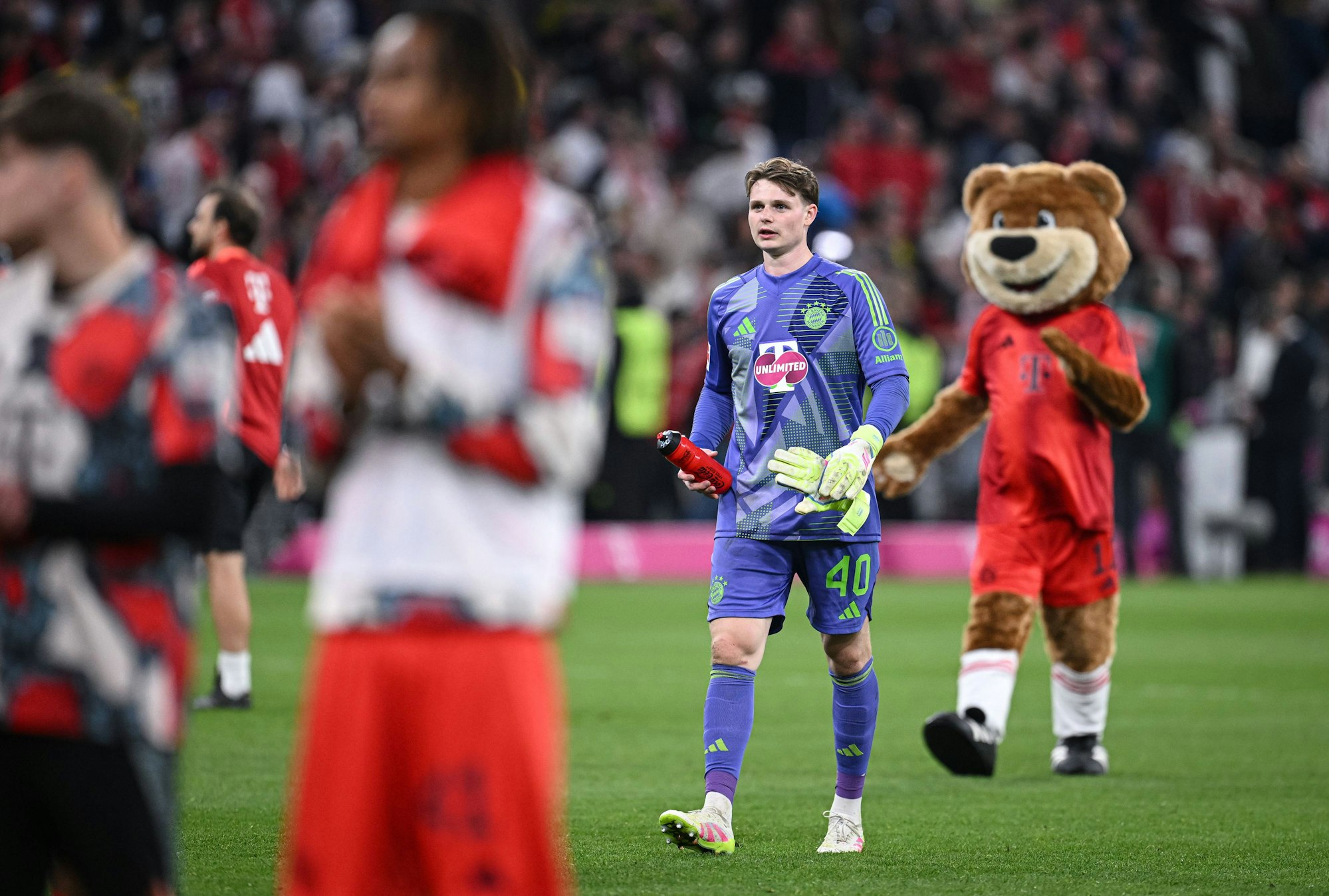 Jonas Urbig geht nach dem Spiel Richtung Fankurve. Im Hintergrund ist Maskottchen Berni zu sehen.