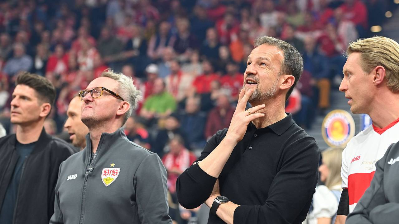 Fredi Bobic und Alexander Wehrle gucken nach oben auf den Videowürfel.