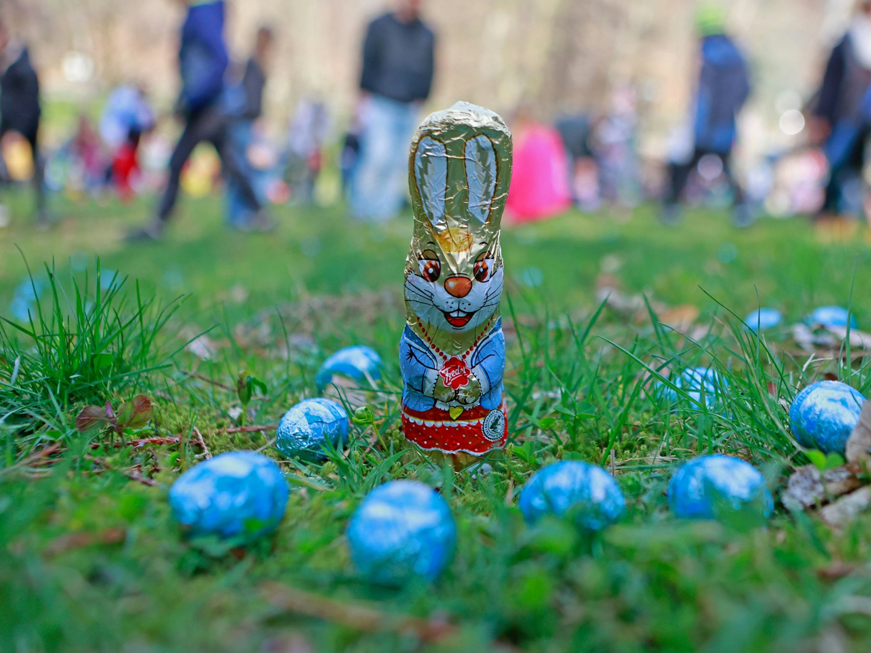Süßigkeiten zum Osterfest liegen auf einer Wiese im Garten.