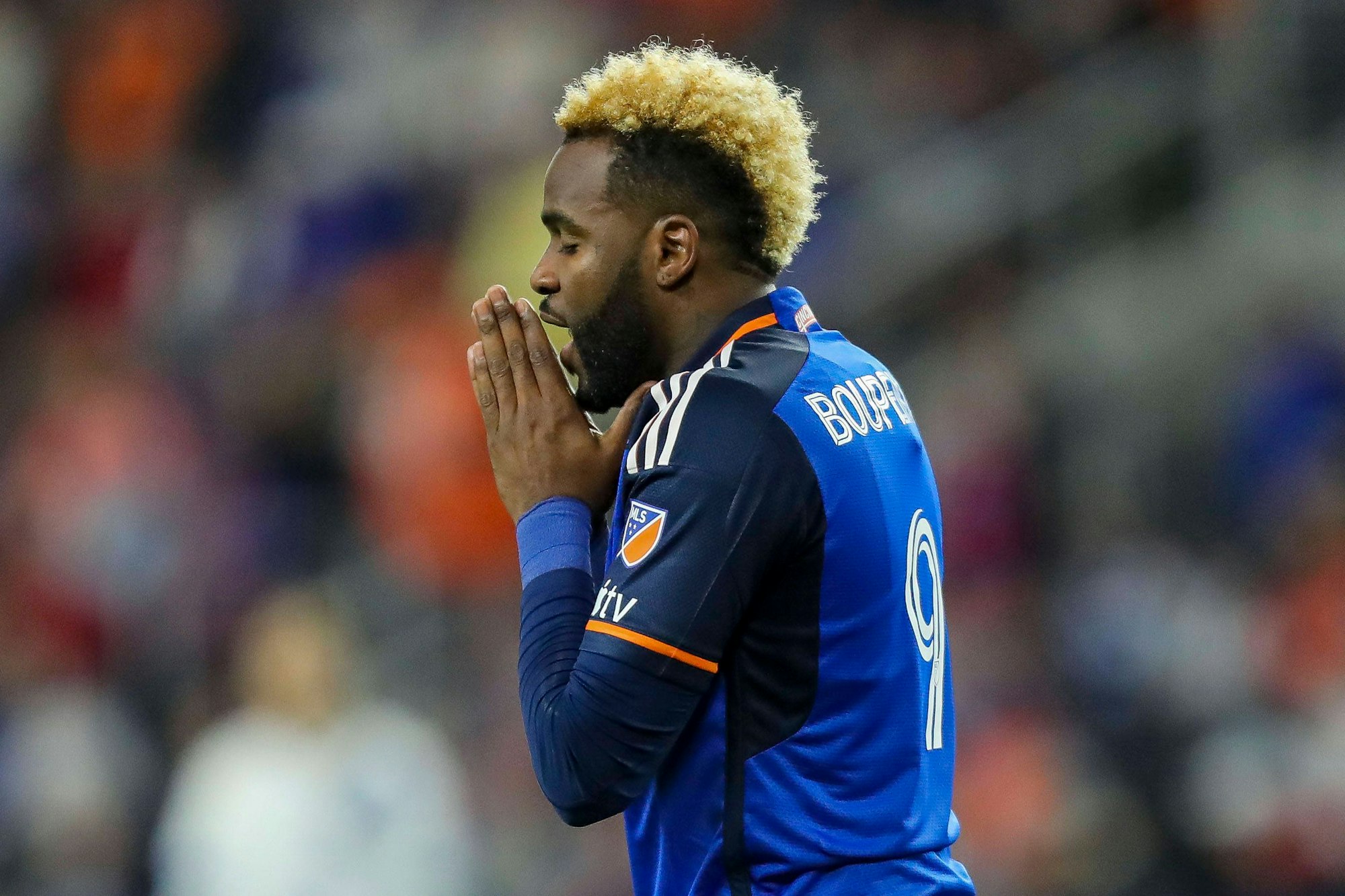 Aaron Boupendza hält seine Hände vor dem Gesicht und betet.