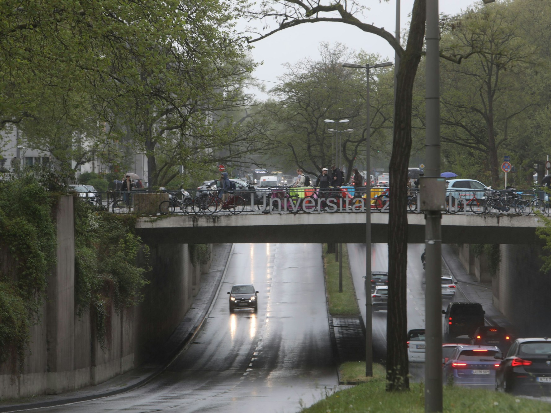 Autos fahren bei Regen durch eine Unterführung.