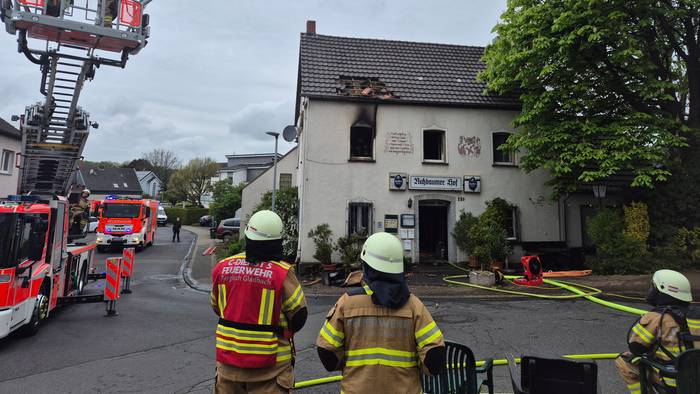 Feuerwehrleute stehen am Einsatzort.