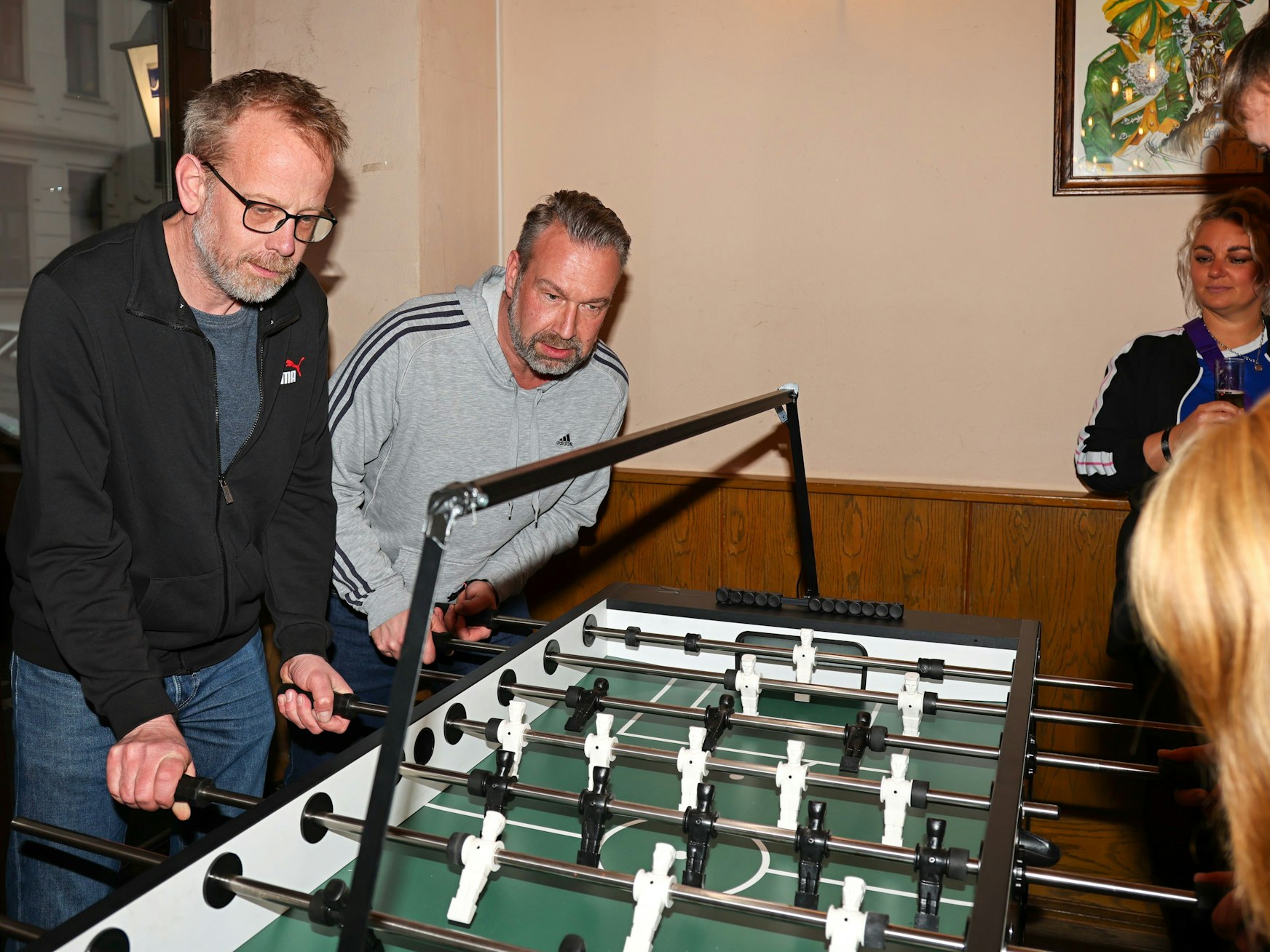 Zwei Männer kickern.