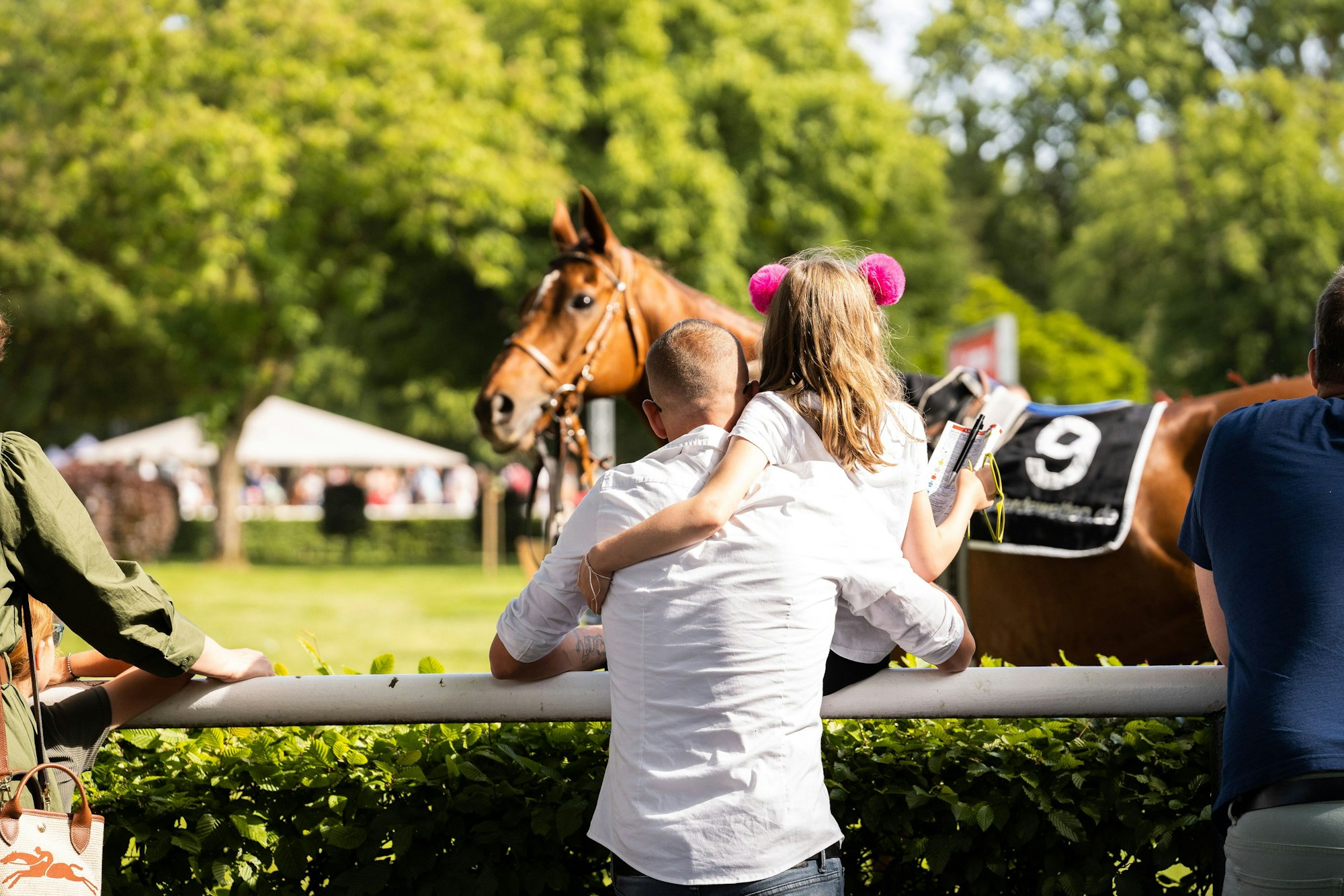 Vater und Tochter schauen auf ein Pferd beim Besuch des Kölner Renn-Verein 1897 e. V. auf der Galopprennbahn in Köln Weidenpesch.