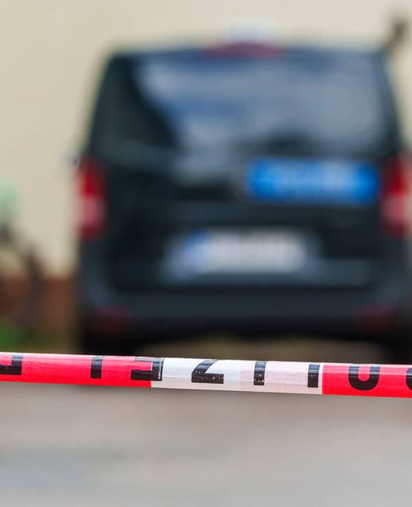 Ein Polizeifahrzeug steht hinter Absperrband.