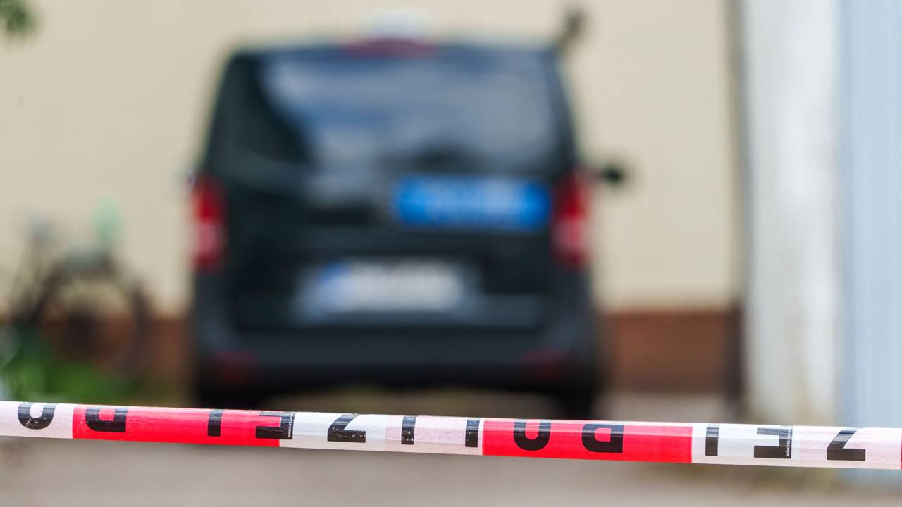 Ein Polizeifahrzeug steht hinter Absperrband.